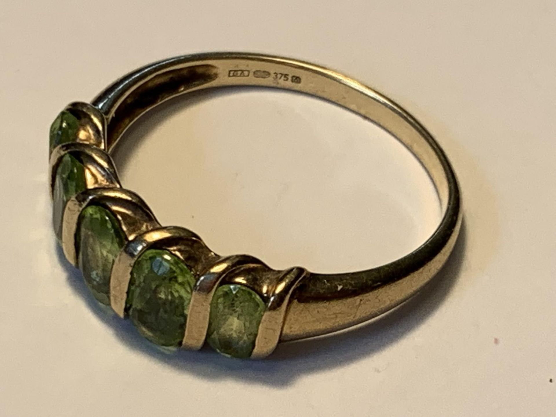 A 9 CARAT GOLD RING WITH FIVE IN LINE PERIDOTS SIZE Q - Image 2 of 3