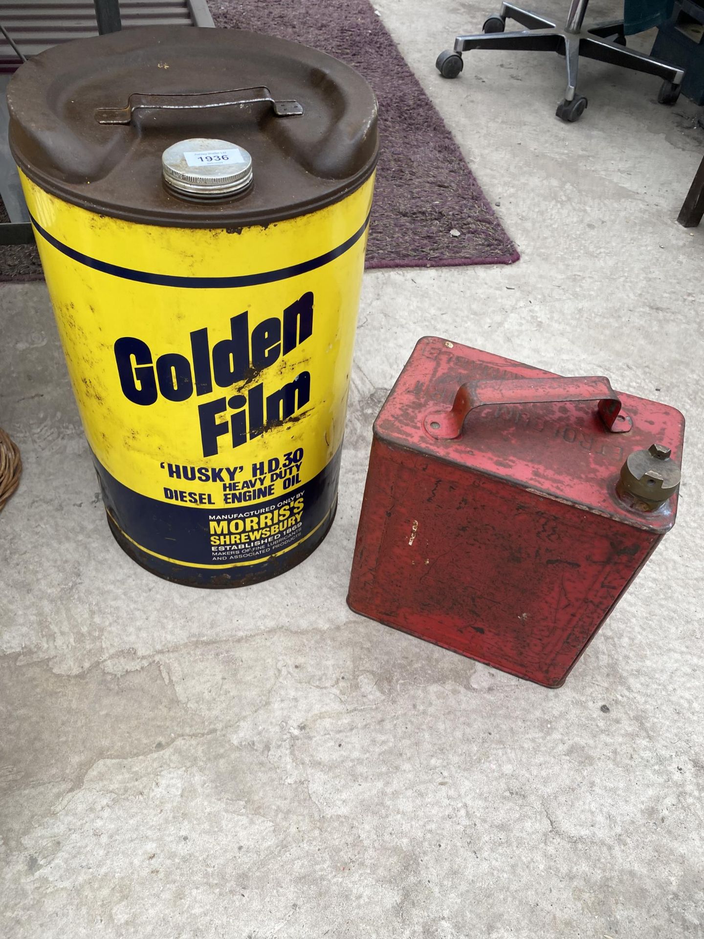 A VINTAGE FUEL CAN WITH BRASS CAP AND A GOLDEN FILM OIL DRUM