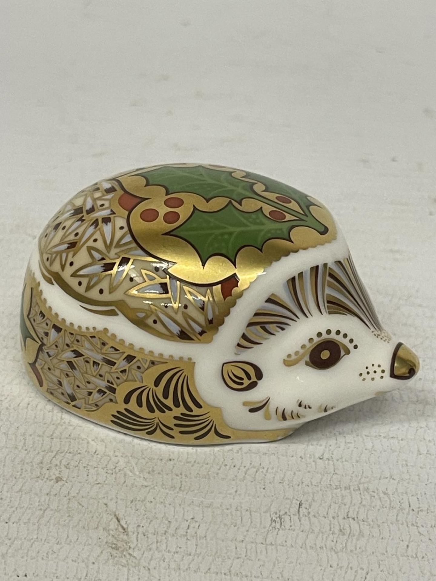 A ROYAL CROWN DERBY HOLLY HEDGEHOG WITH GOLD STOPPER