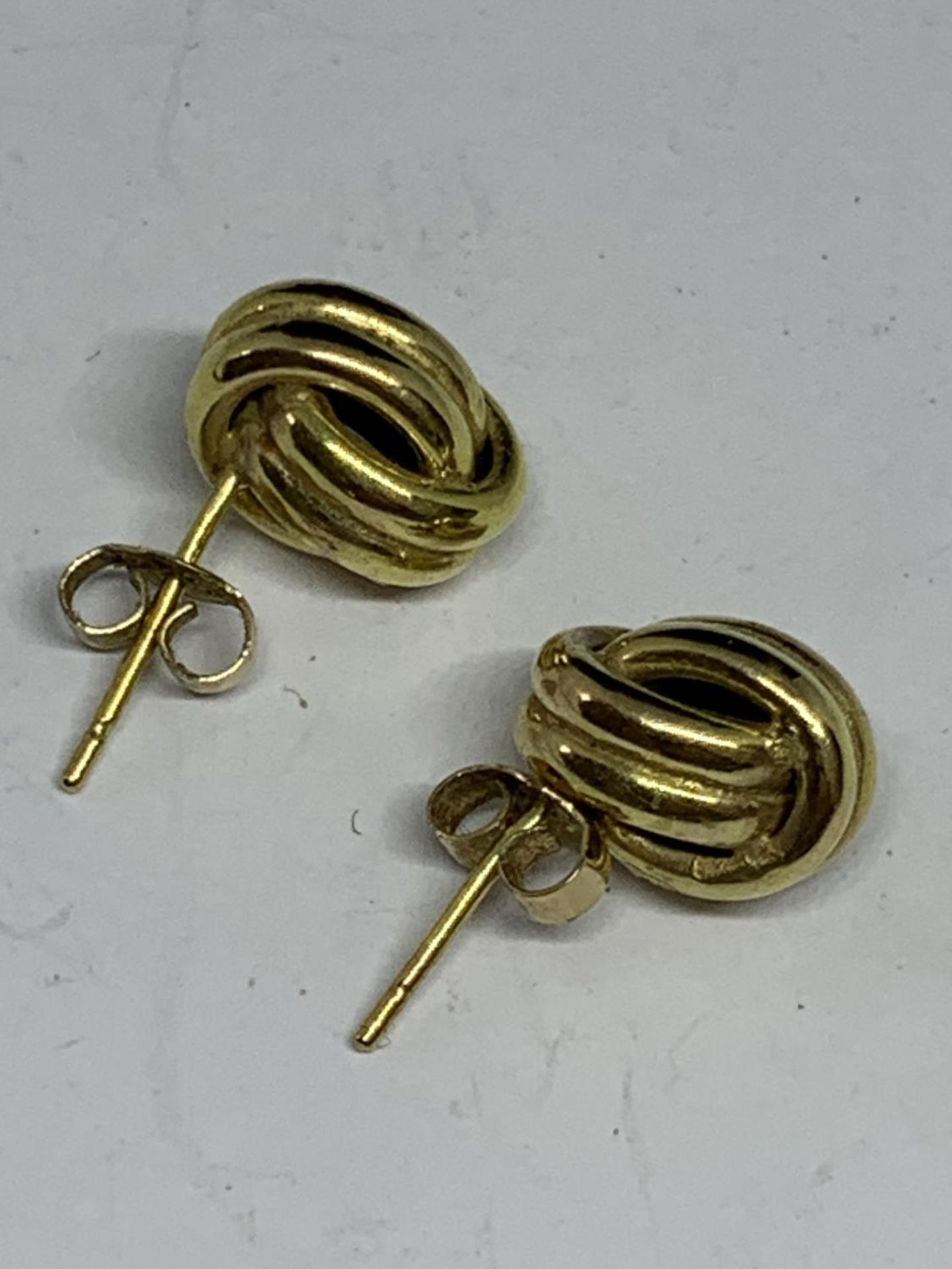 A PAIR OF 9 CARAT GOLD EARRINGS IN A KNOT DESIGN GROSS WEIGHT 1.08 GRAMS - Image 2 of 3