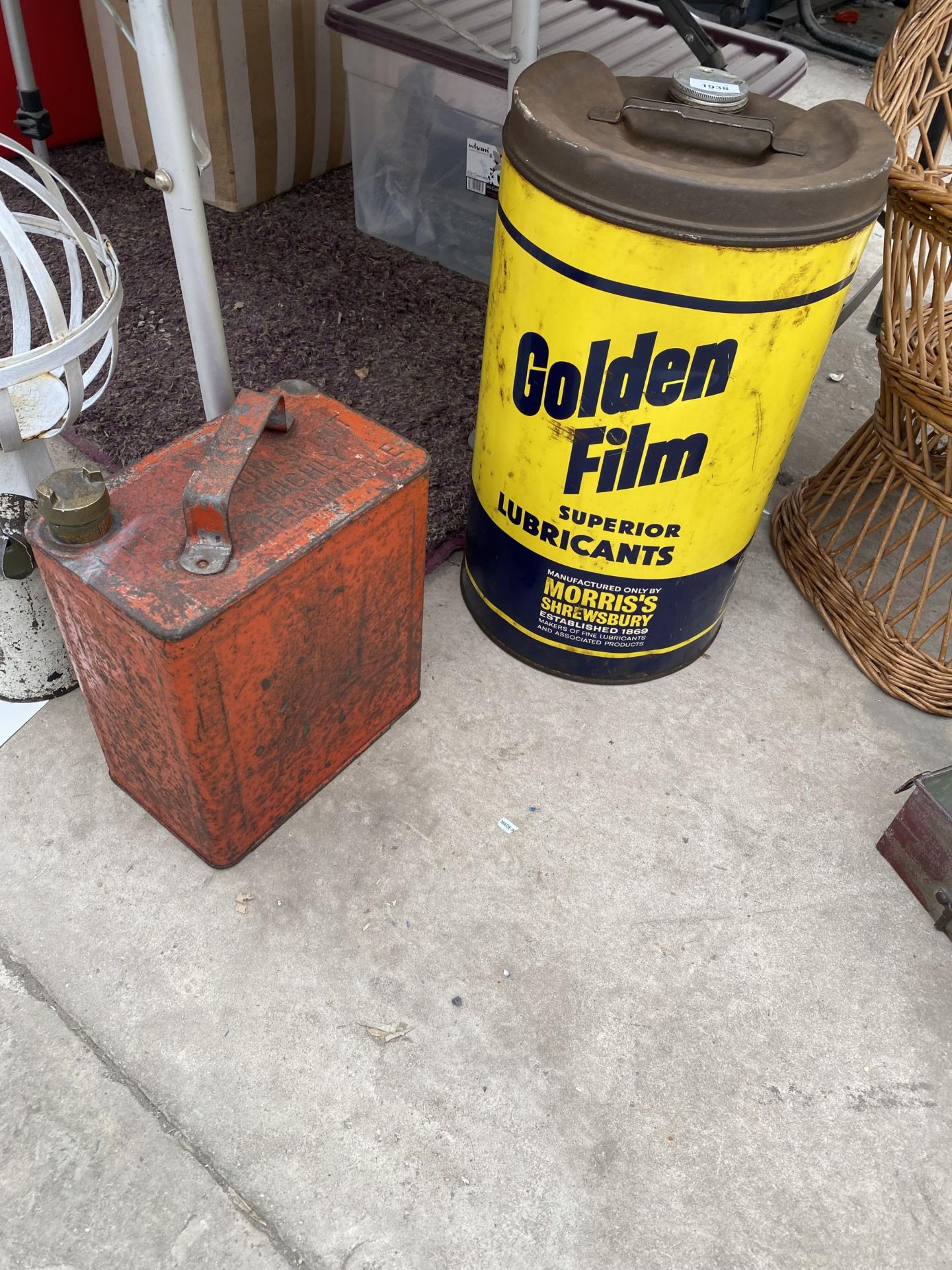 A VINTAGE FUEL CAN WITH BRASS CAP AND A GOLDEN FILM OIL DRUM