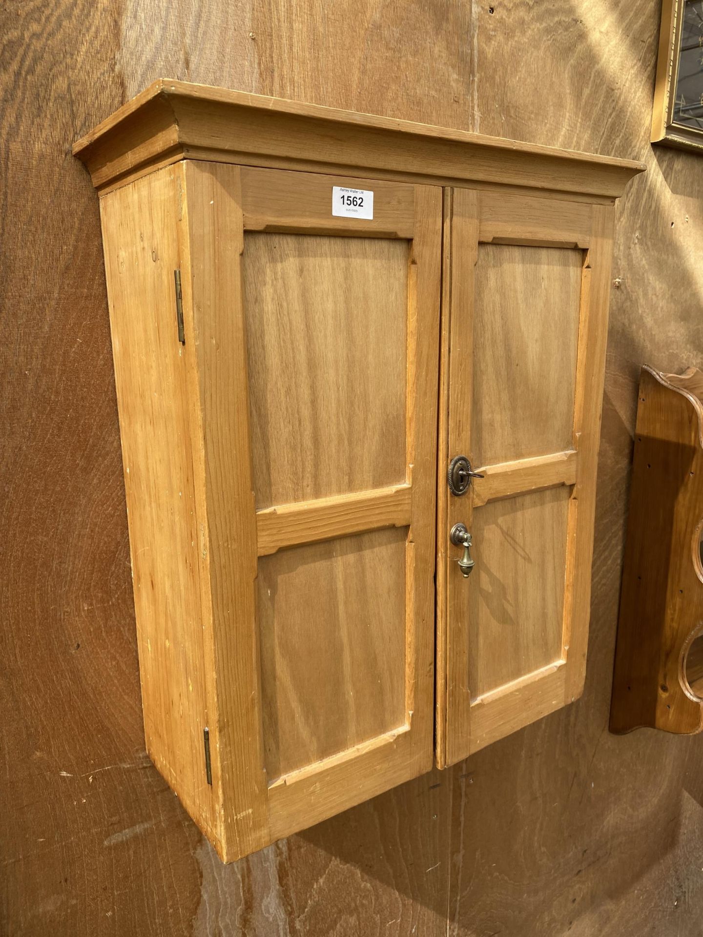 A PINE WALL CUPBOARD WITH THREE INTERNAL SHELVES AND A DRAWER