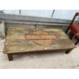 A RUSTIC LOW COFFEE TABLE, THE TOP BEARING HARLEY-DAVIDSON MOTORCYCLES LOGO, 56X27"