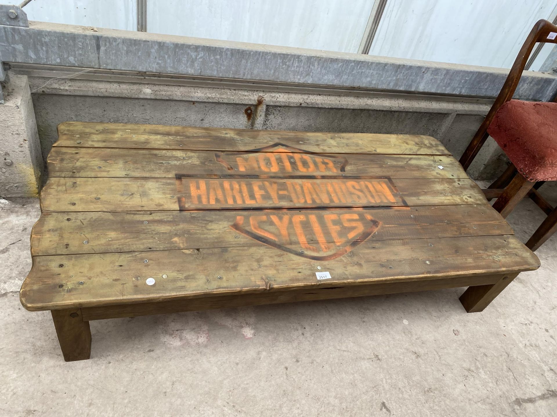 A RUSTIC LOW COFFEE TABLE, THE TOP BEARING HARLEY-DAVIDSON MOTORCYCLES LOGO, 56X27"