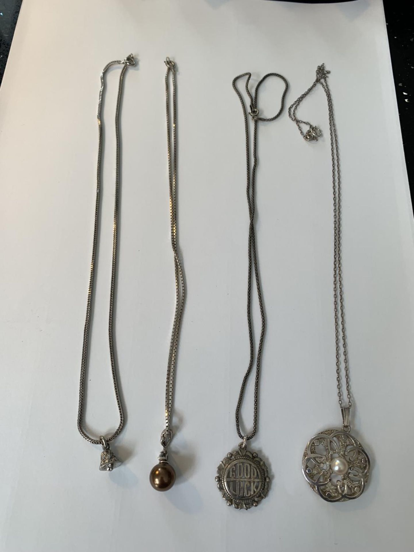 FOUR SILVER NECKLACES WITH PENDANTS