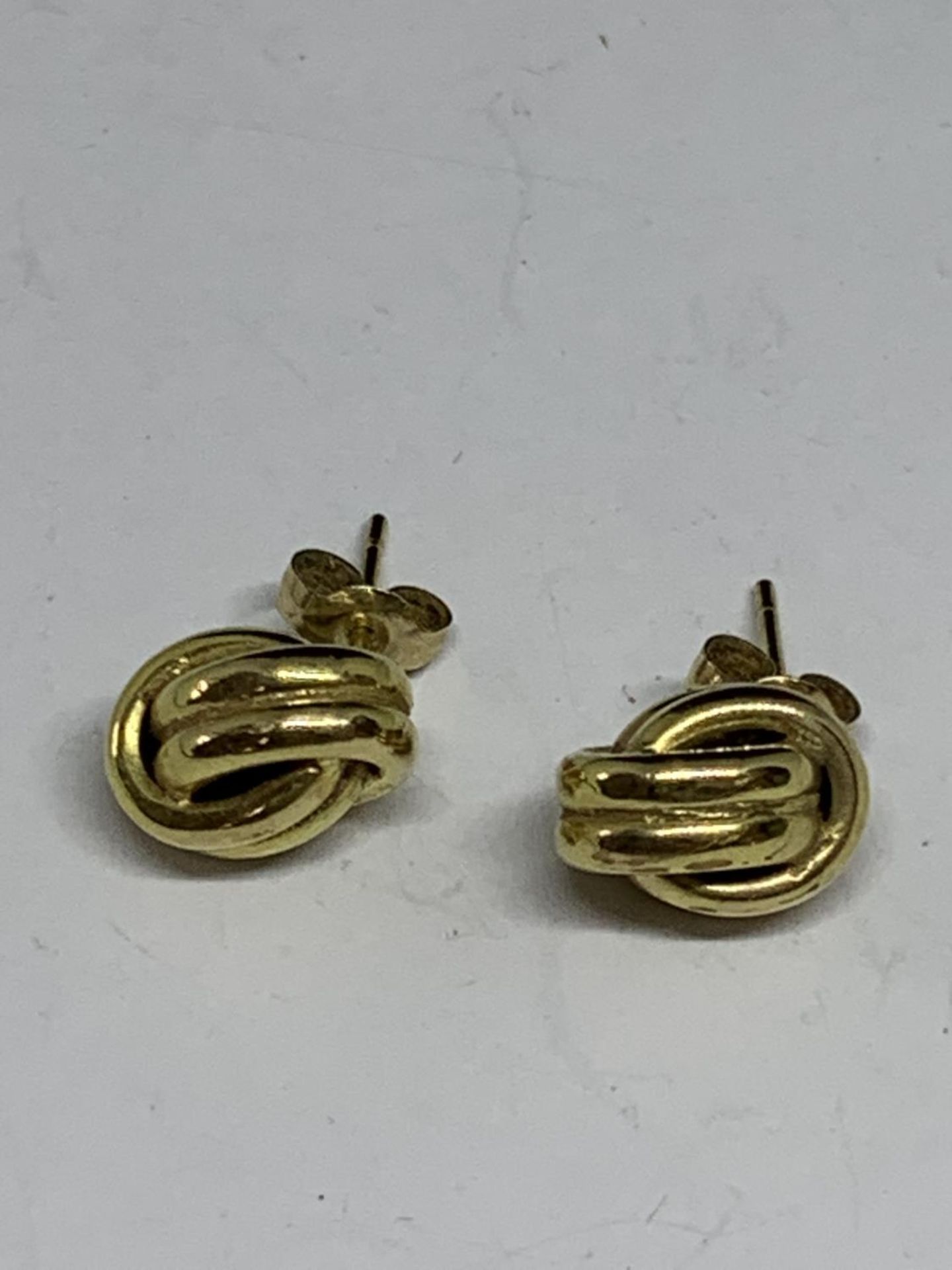 A PAIR OF 9 CARAT GOLD EARRINGS IN A KNOT DESIGN GROSS WEIGHT 1.08 GRAMS