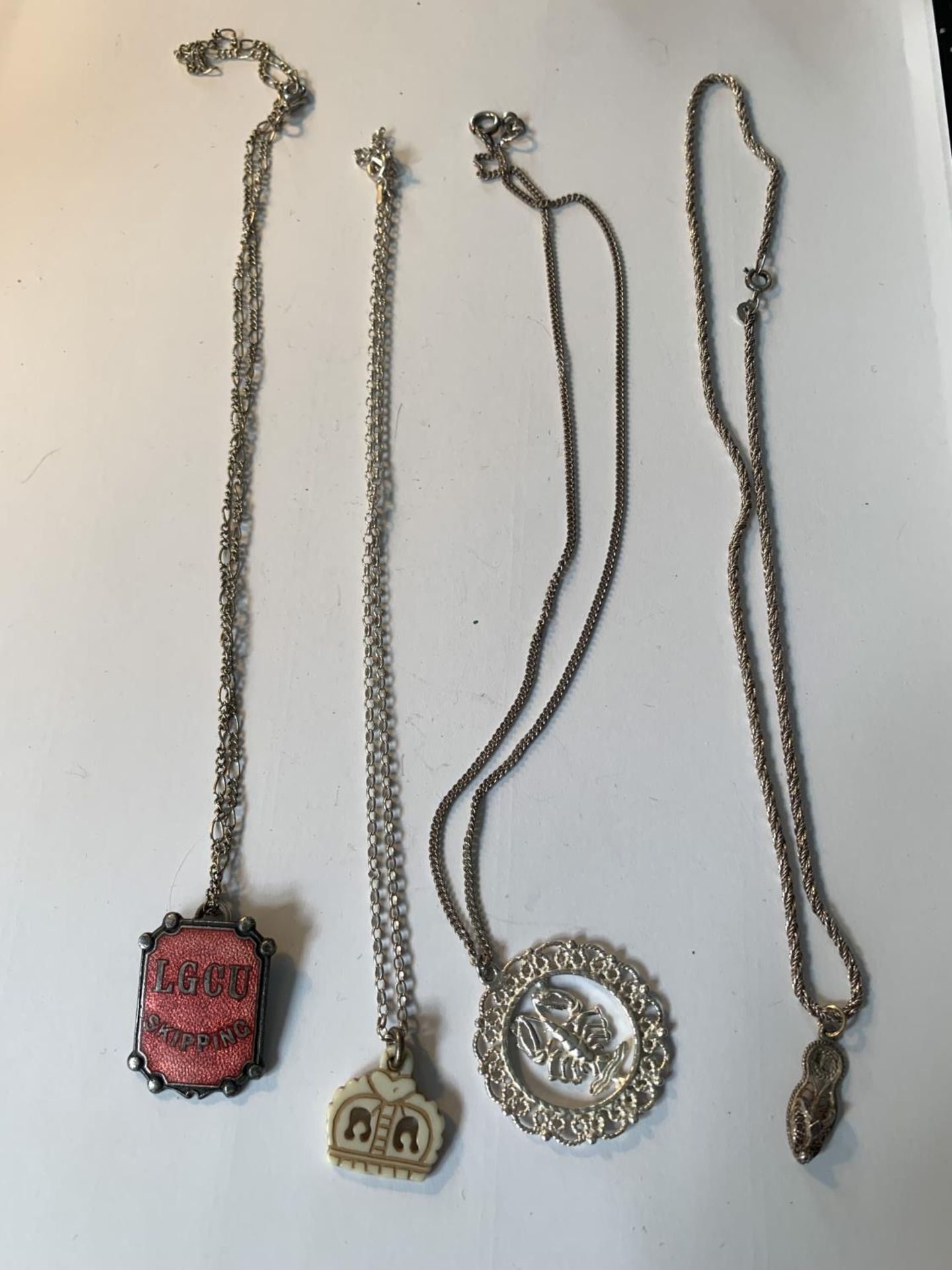 FOUR SILVER NECKLACES WITH PENDANTS