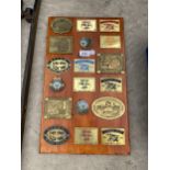 A WOODEN PLAQUE WITH VARIOUS BRASS STEAM RALLY PLAQUES ATTATCHED