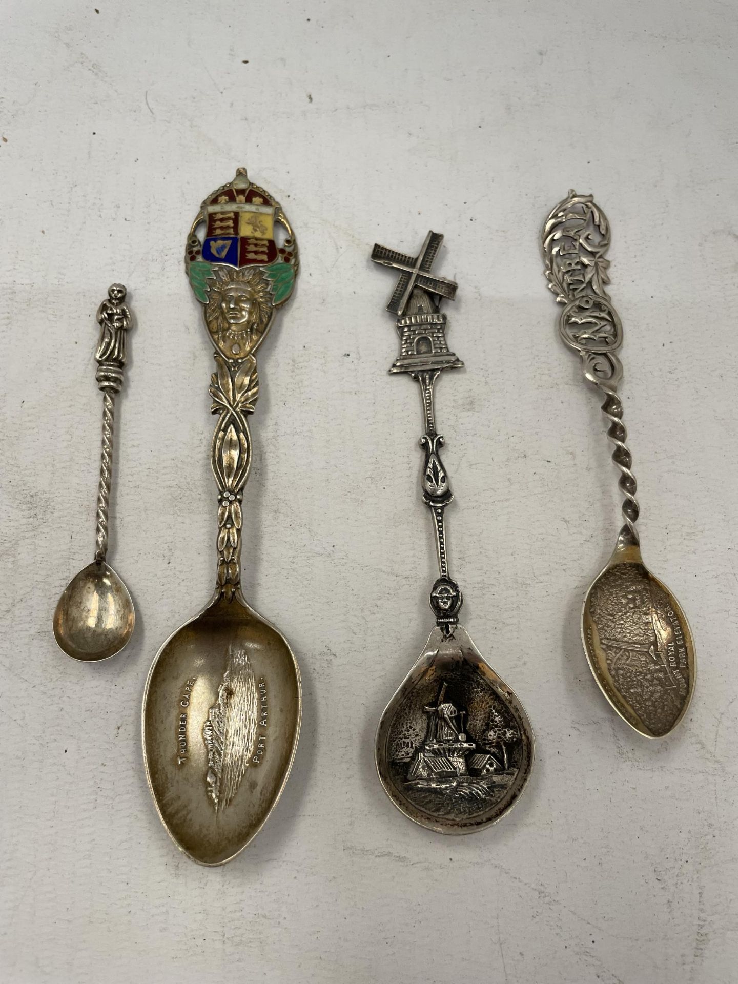 A GROUP OF HALLMARKED SILVER TEASPOONS, ONE WITH WINDMILL DESIGN AND ONE WITH ENAMEL DESIGN COAT
