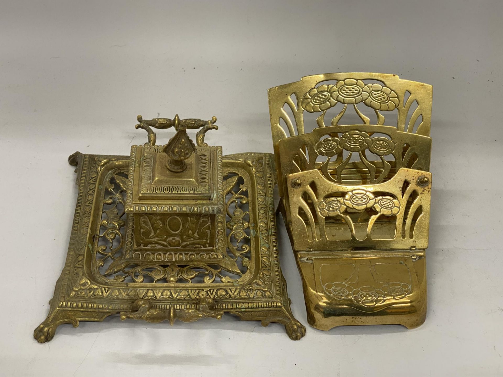 AN ART NOUVEAU STYLE BRASS INKWELL WITH LETTER RACK PLUS AN ORNATE BRASS INKWELL