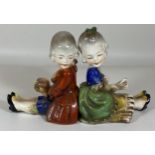 A PAIR OF EARLY 1930'S HUMMEL POTTERY NURSERY BOOKENDS OF A BOY AND GIRL, BOY A/F, HEIGHT 13CM