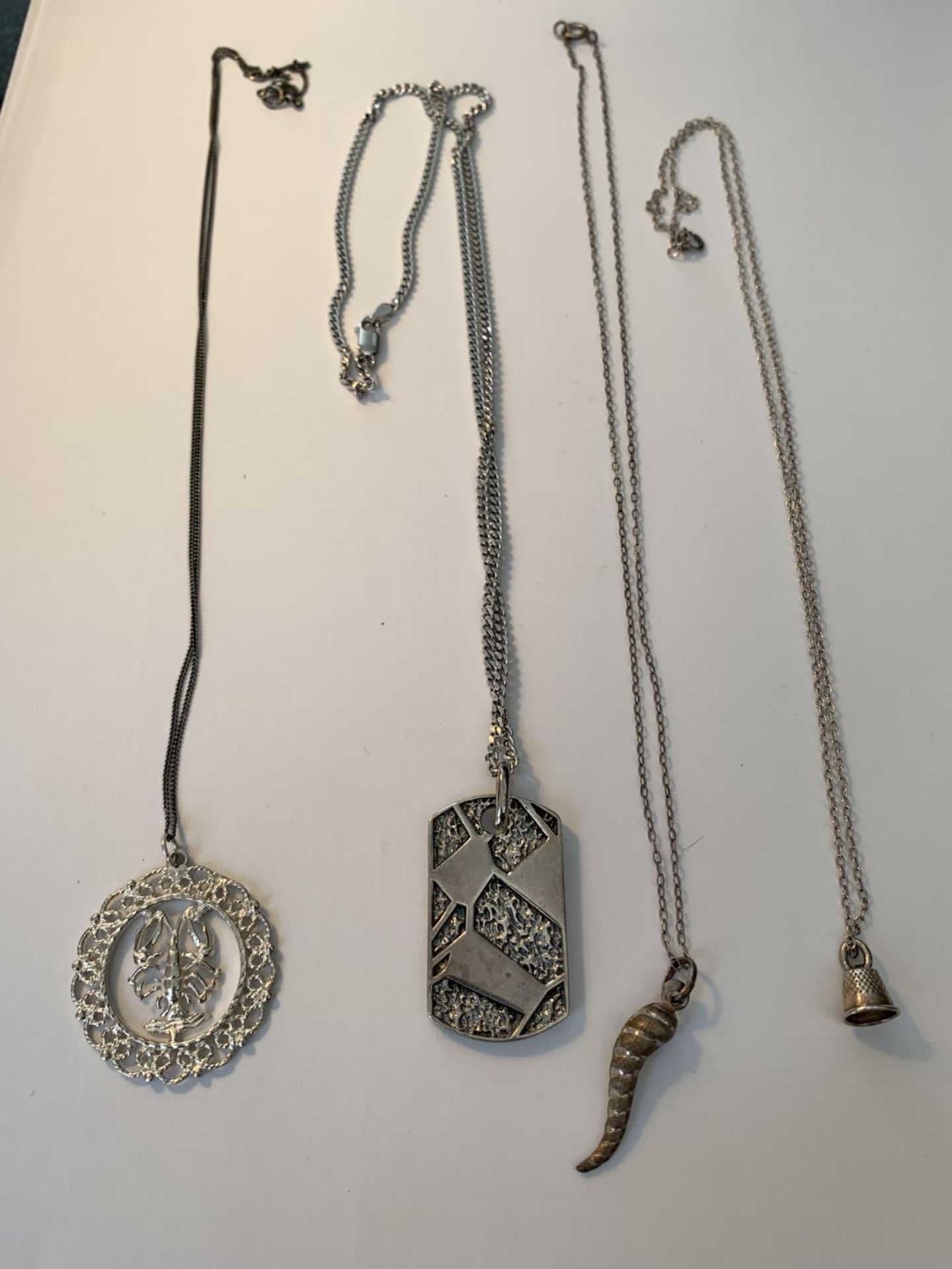 FOUR SILVER NECKLACES WITH PENDANTS