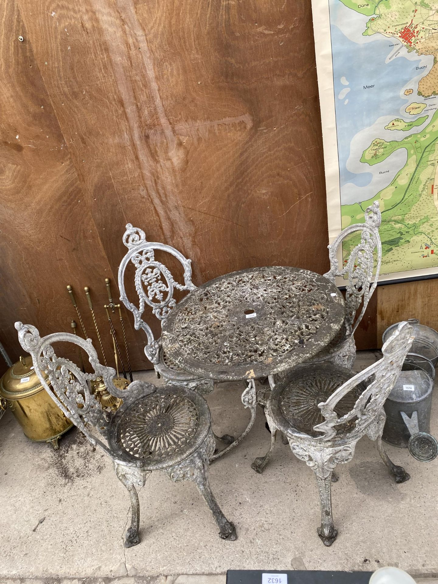 A VICTORIAN STYLE CAST ALLOY BISTRO SET COMPRISING OF A ROUND TABLE AND FOUR CHAIRS