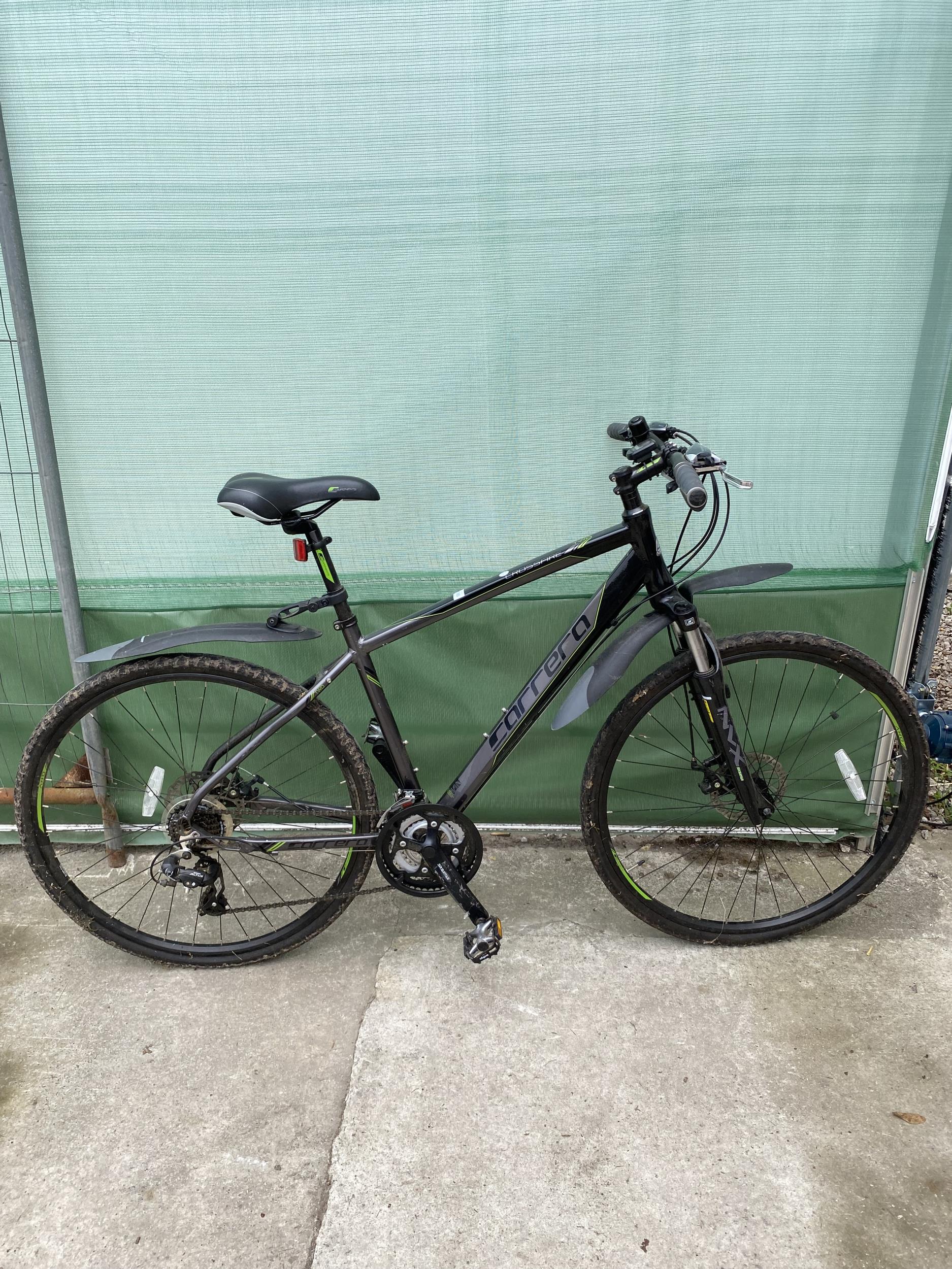 A CARRERA CROSSFIRE GENTS MOUNTAIN BIKE WITH FRONT SUSPENSION, DISC BRAKES AND 21 SPEED SHIMANO GEAR