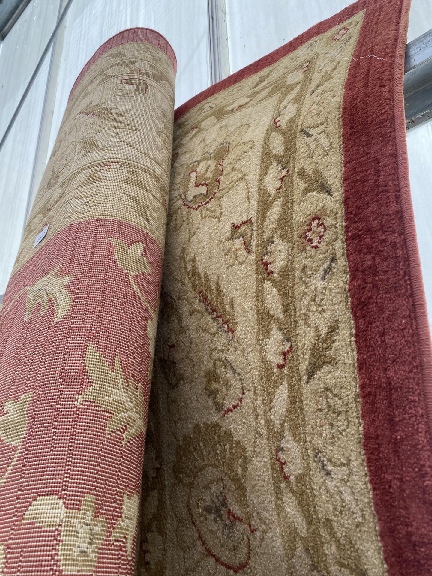 A LARGE RED AND CREAM PATTERNED RUG - Image 2 of 2