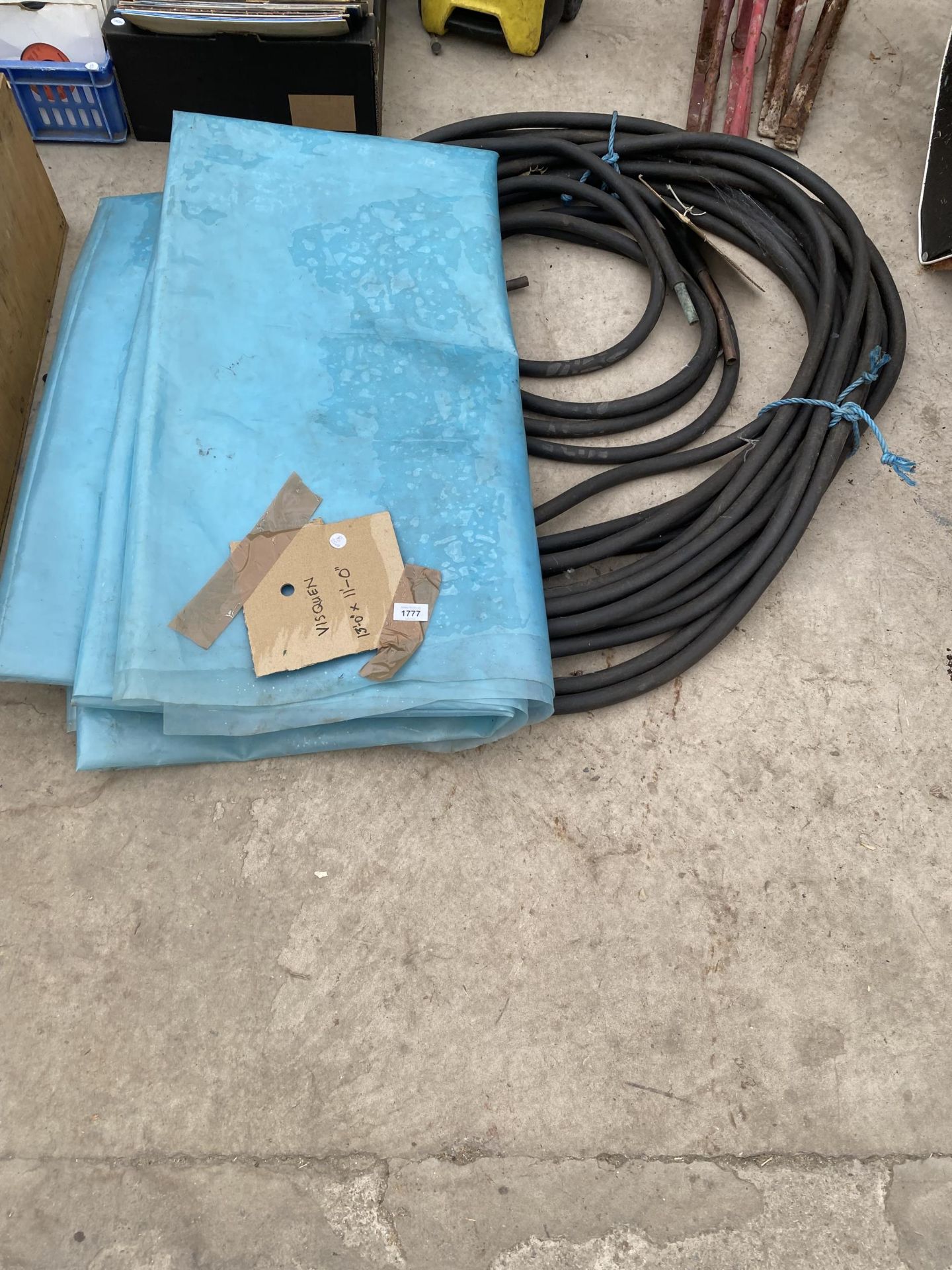 A LARGE QUANTITY OF RUBBER HOSE AND A SHEET OF VISQUEN