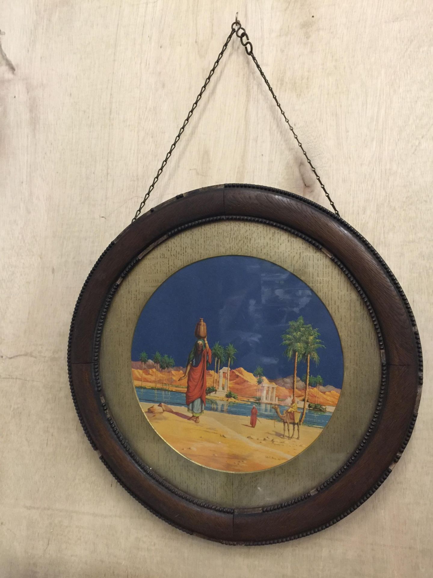 A 1923 CIRCULAR OAK WALL PLAQUE WITH ART WORK BY VICTOR E PIKUP