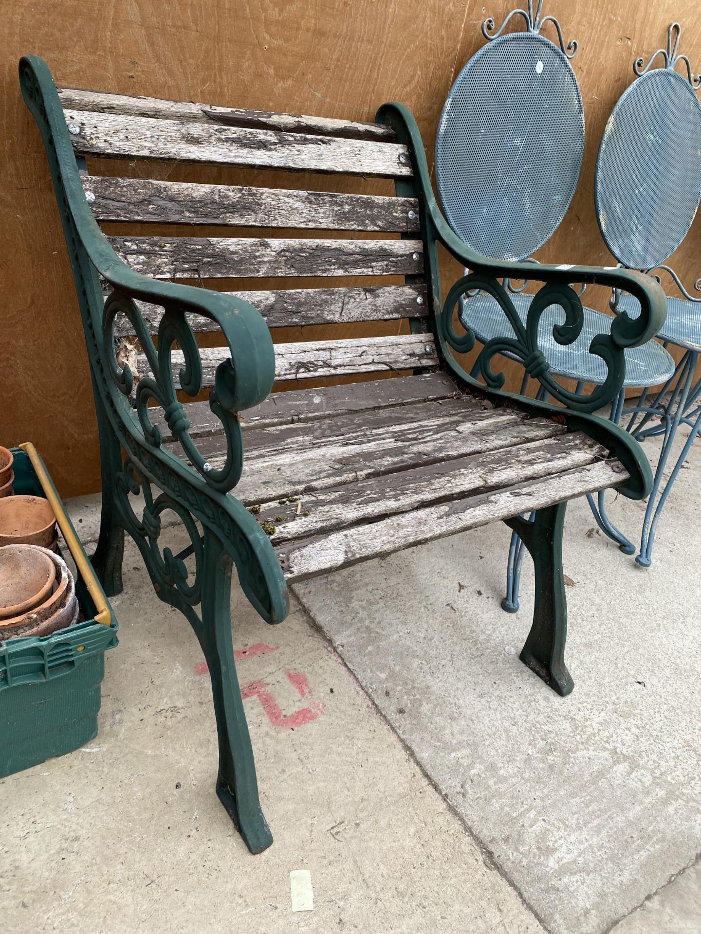 A WOODEN SLATTED GARDEN CHAIR WITH CAST ENDS