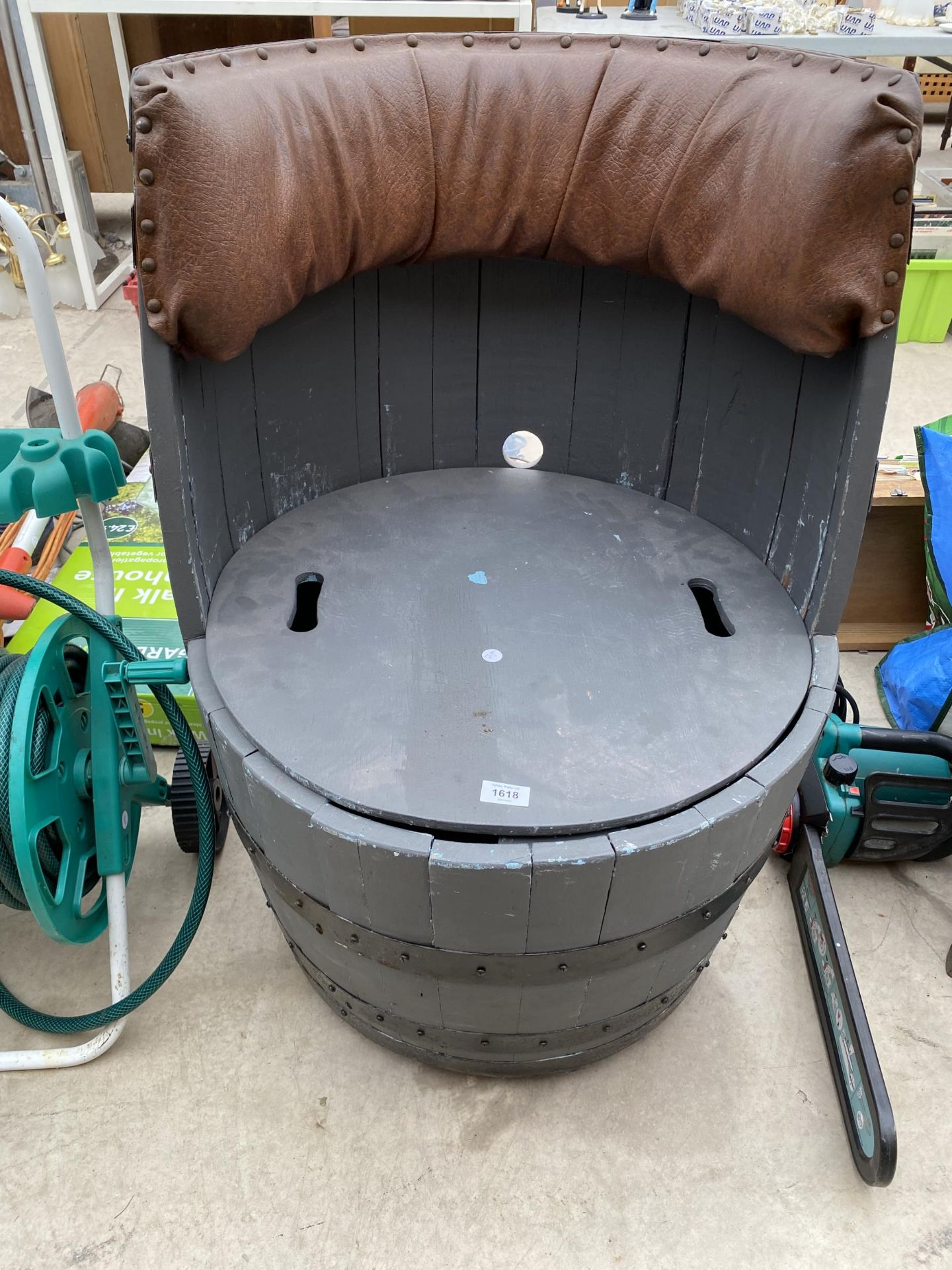 A DECORATIVE OAK BARREL SEAT WITH UNDER SEAT STORAGE