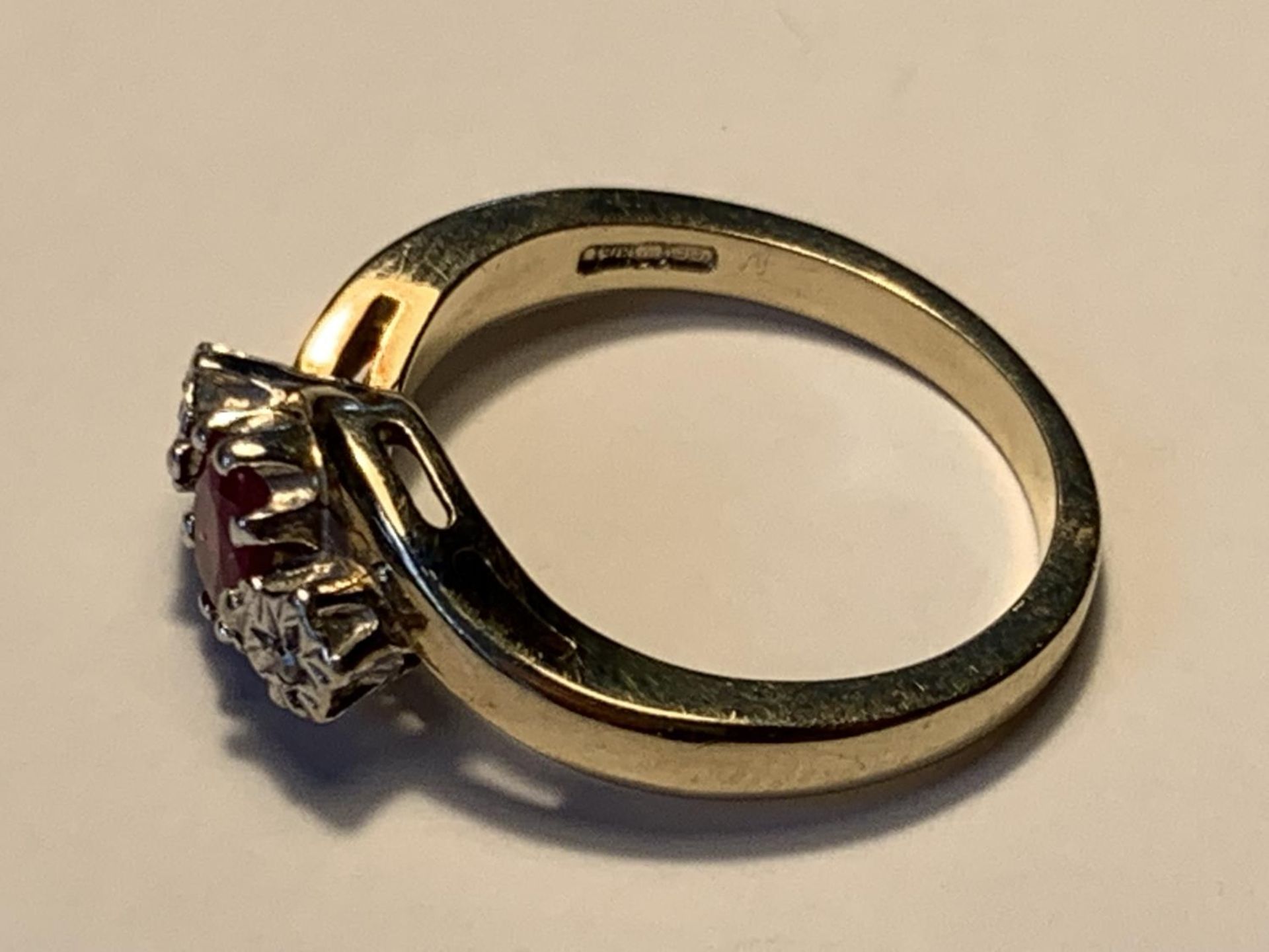 A 9 CARAT GOLD RING WITH A CENTRE RUBY AND A DIAMOND EACH SIDE SIZE L - Image 2 of 3