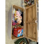 A WOODEN TOY BOX CONTAINING AN ASSORTMENT OF TOYS TO INCLUDE DOLLS AND BOARD GAMES ETC