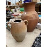 A LARGE TERRACOTTA URN PLANTER AND A FURTHER TERRACOTTA TWIN HANDLED POT