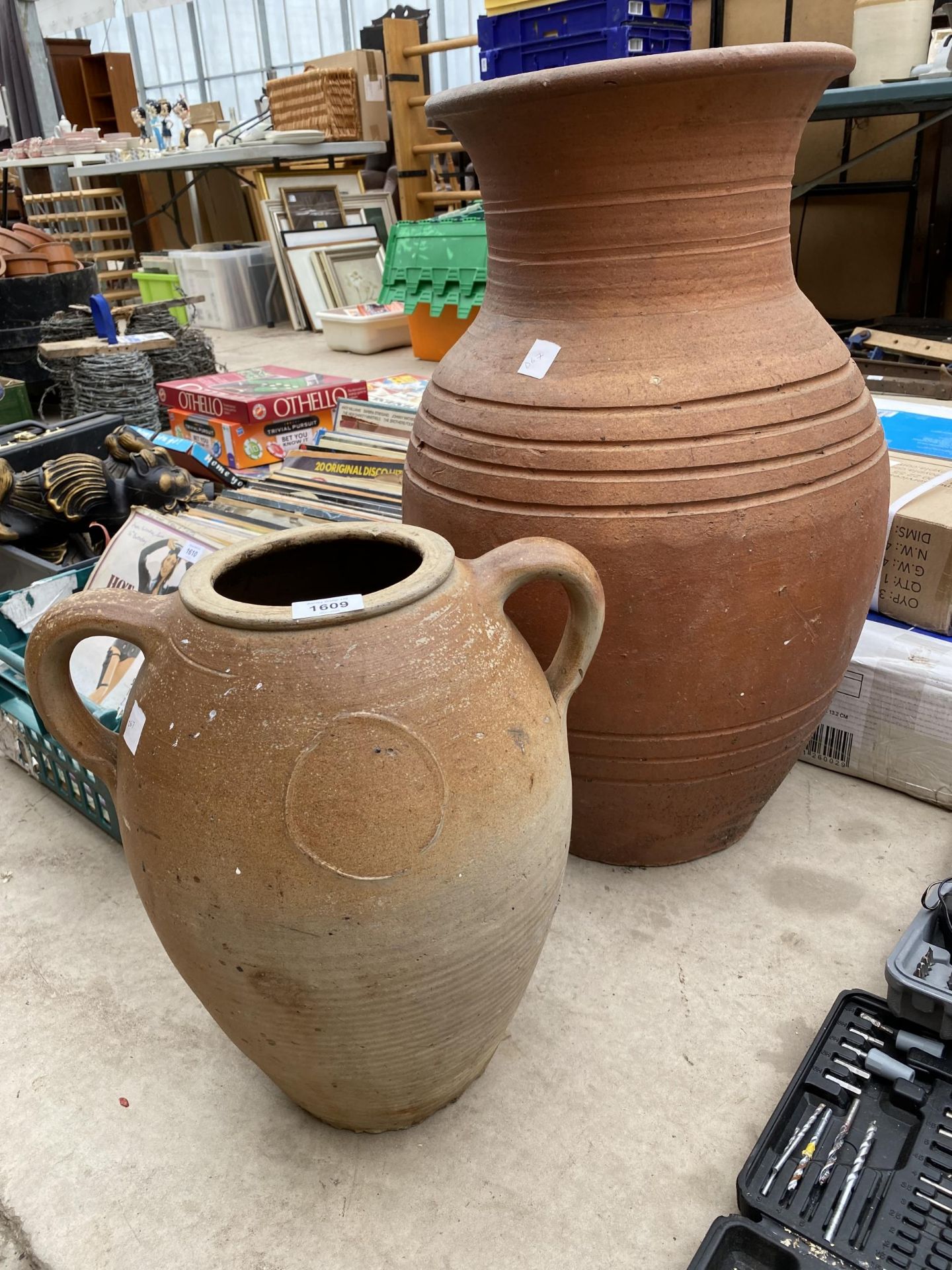 A LARGE TERRACOTTA URN PLANTER AND A FURTHER TERRACOTTA TWIN HANDLED POT