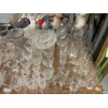 A VERY LARGE QUANTITY OF GLASSWARE TO INCLUDE VASES, BOWLS, WINE, SHERRY, CHAMPAGNE FLUTES,