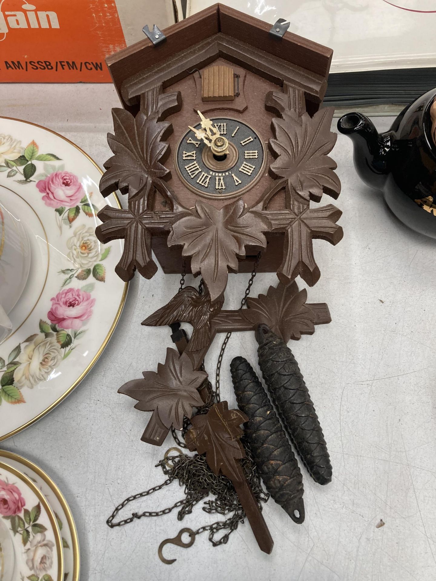 A WOODEN CUCKOO CLOCK WITH WEIGHTS