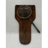 A BRASS MAGNIFYING GLASS IN A LEATHER POUCH