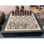 AN ORIENTAL THEMED CHESS SET AND BOARD, COMPLETE