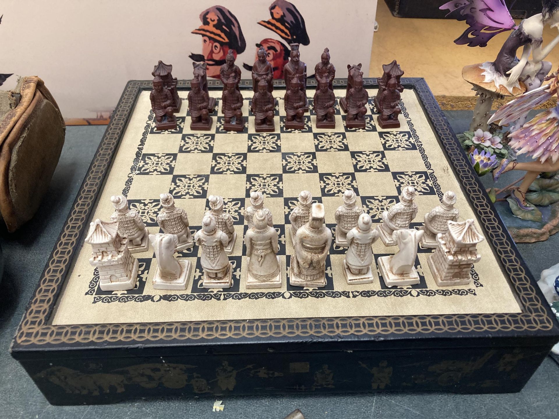 AN ORIENTAL THEMED CHESS SET AND BOARD, COMPLETE