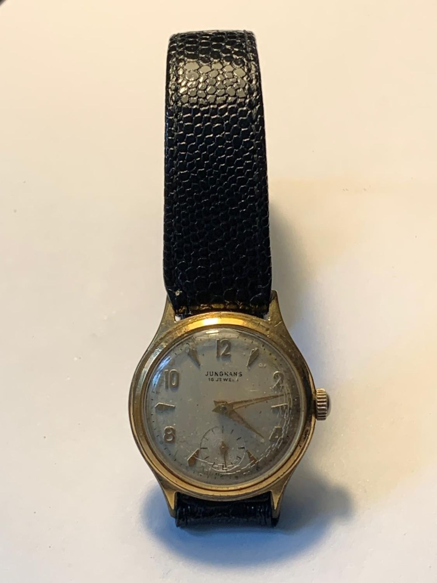 A 1960'S JUNGHANS 16 JEWEL WRIST WATCH WITH SUB DIAL AND BLACK LEATHER STRAP. SEEN WORKING BUT NO