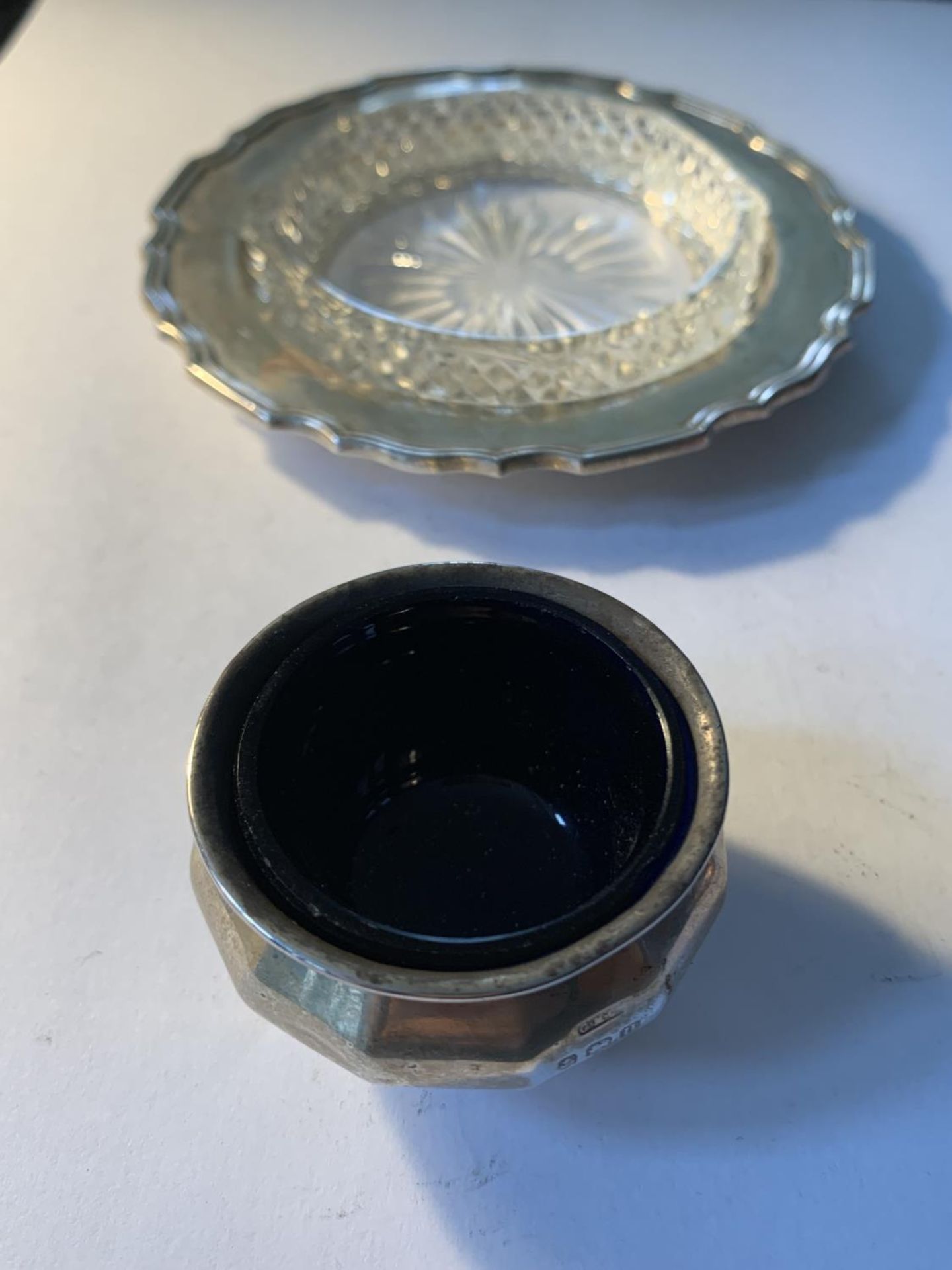 A HALLMARKED BIRMINGHAM SILVER SALT WITH BLUE GLASS LINER AND A HALLMARKED SHEFFIELD DISH WITH GLASS
