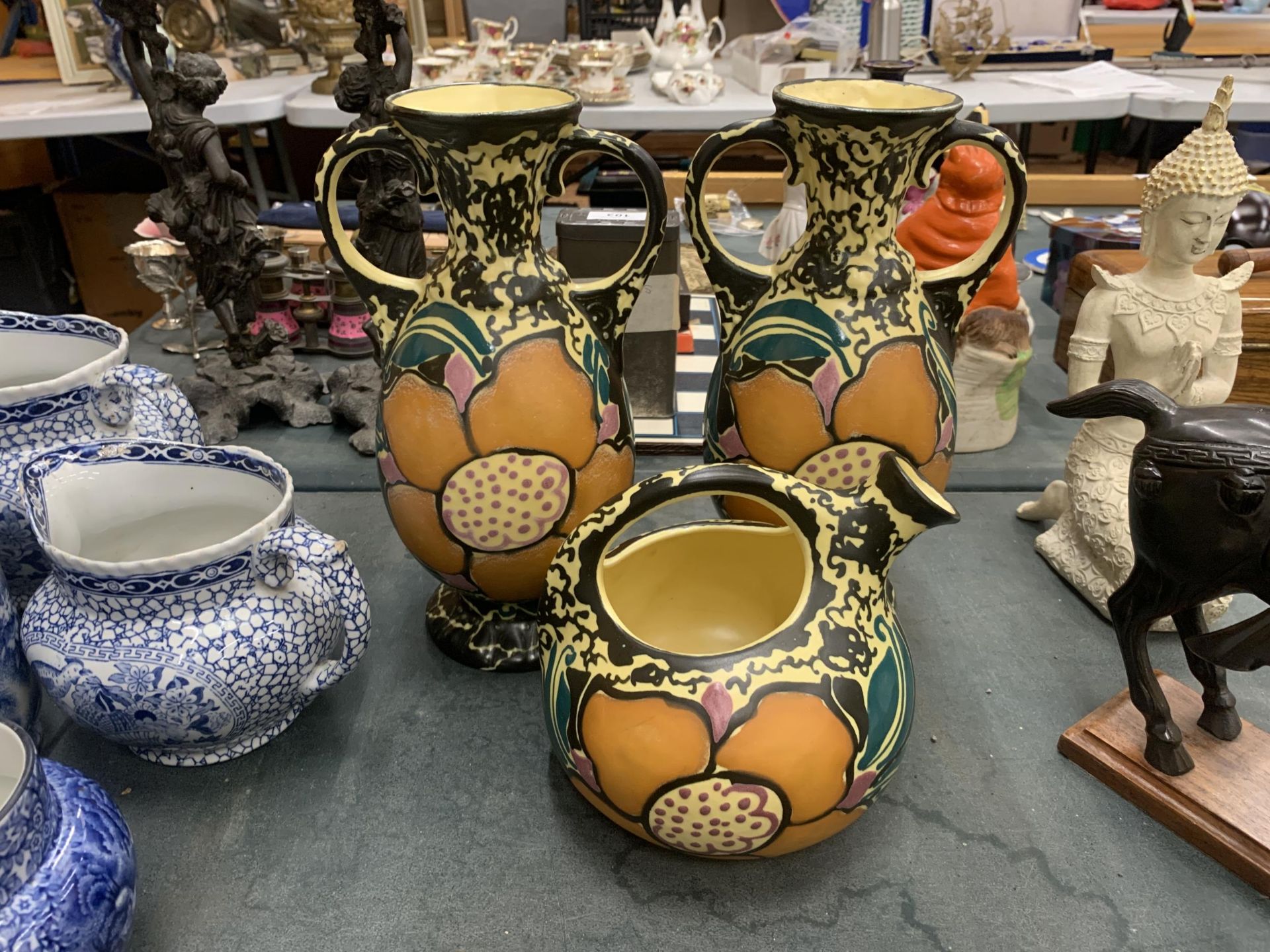 THREE PIECES OF STUDIO POTTERY TO INCLUDE A PAIR OF VASES AND A JUG WITH VIBRANT FLORAL DESIGN