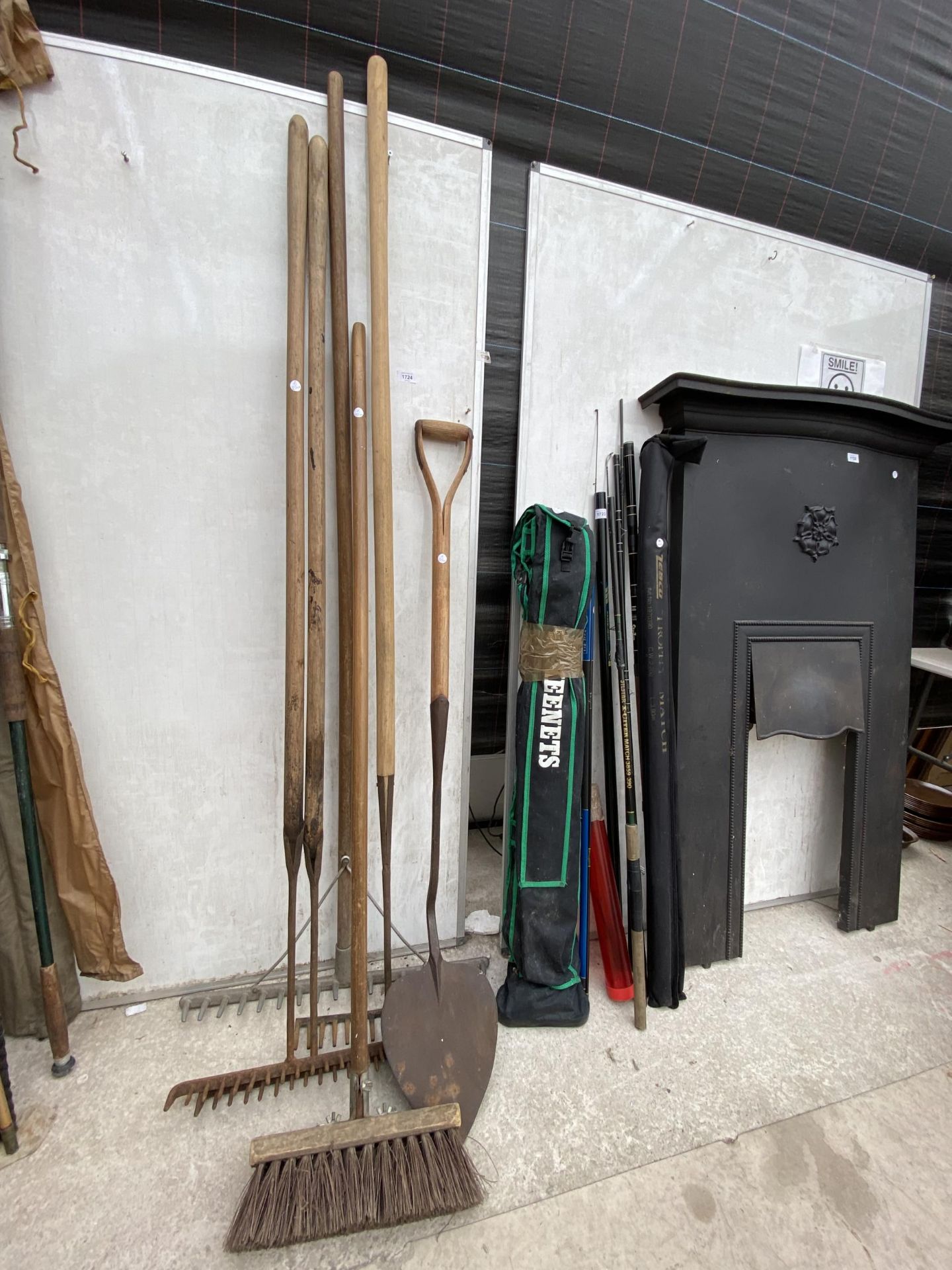 AN ASSORTMENT OF VINTAGE TOOLS TO INCLUDE RAKES AND A SPADE ETC