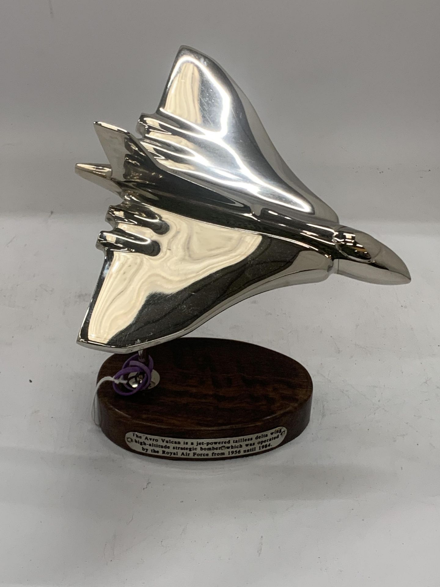 A CHROME VULCAN BOMBER ON A WOODEN BASE