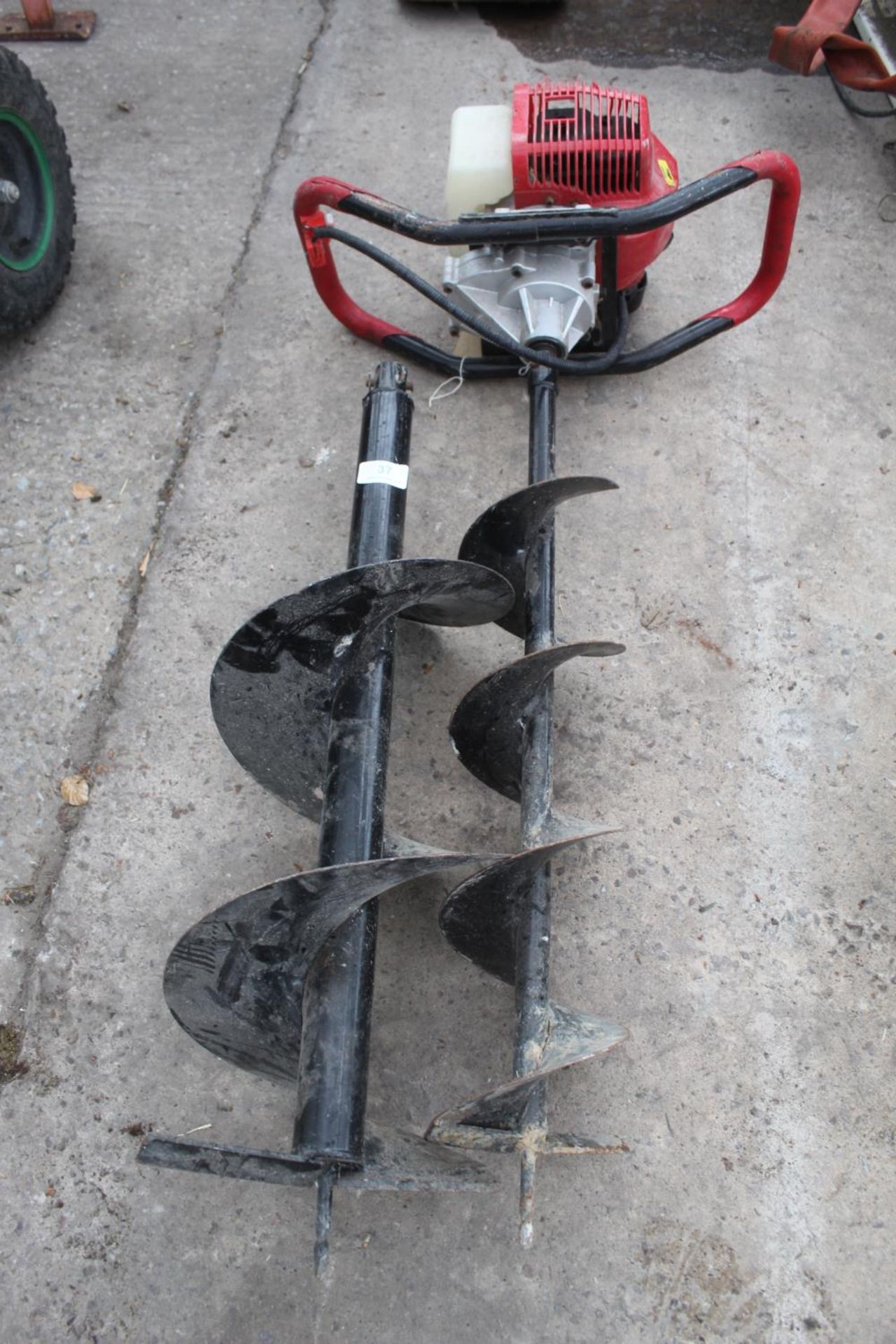 A PETROL ENGINED POST HOLE BORER WITH TWO BORER BLADES + VAT