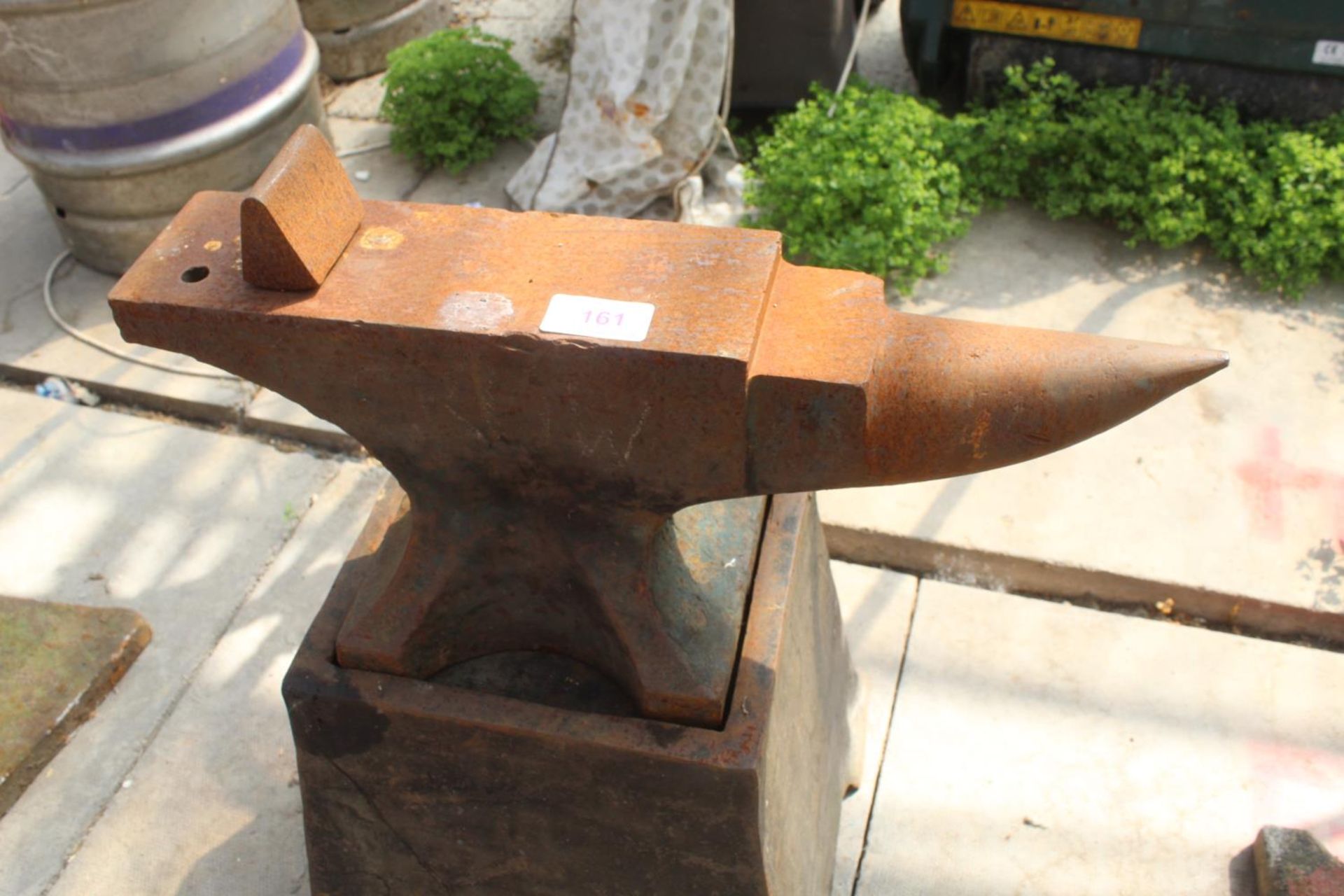 A SMALL VINTAGE CAST IRON BLACKSMITHS ANVIL WITH CAST IRON STAND (ANVIL H:23CM L:50CM STAND H: