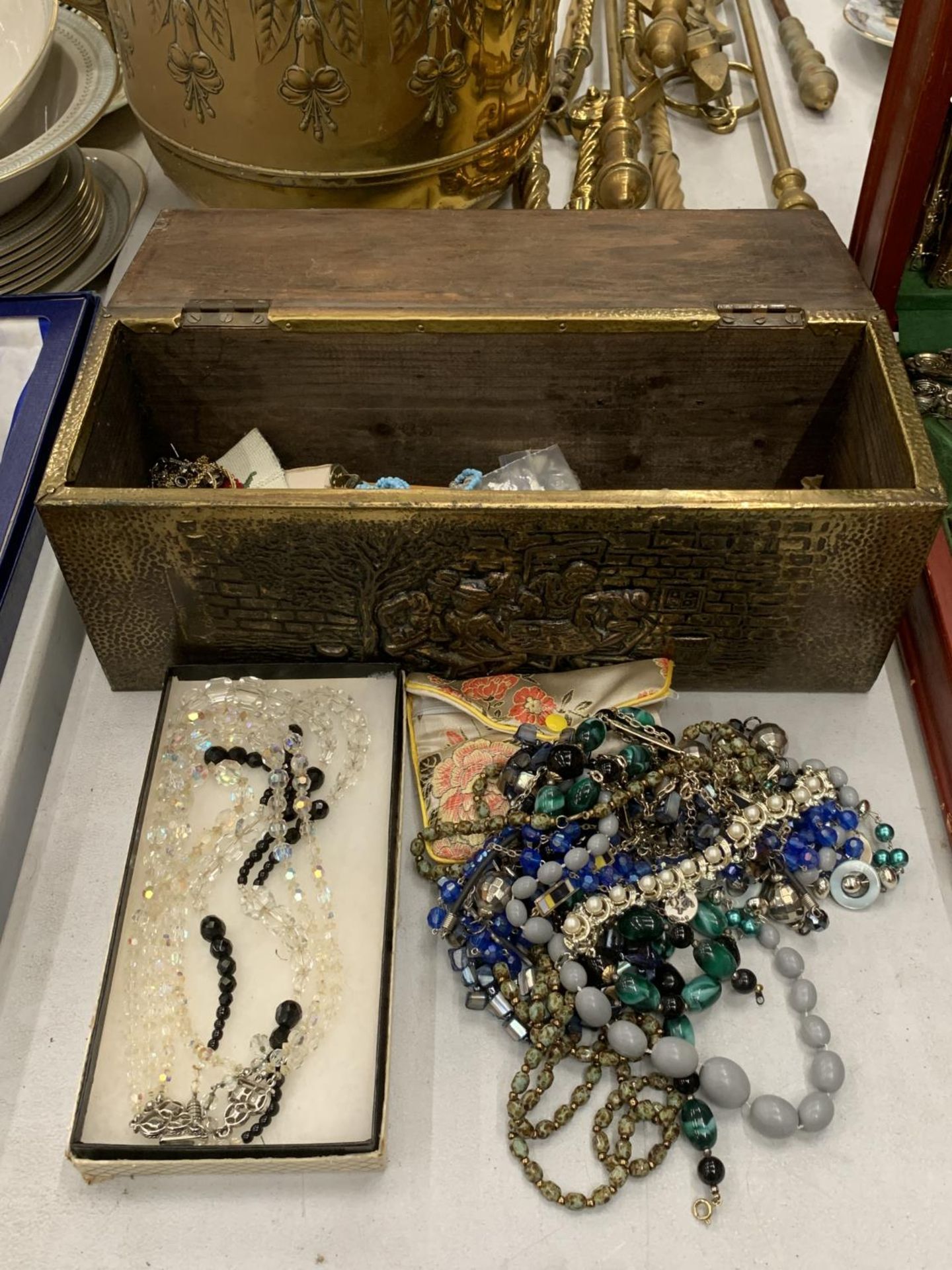 A QUANTITY OF COSTUME JEWELLERY IN BRASS AND WOODEN BOX