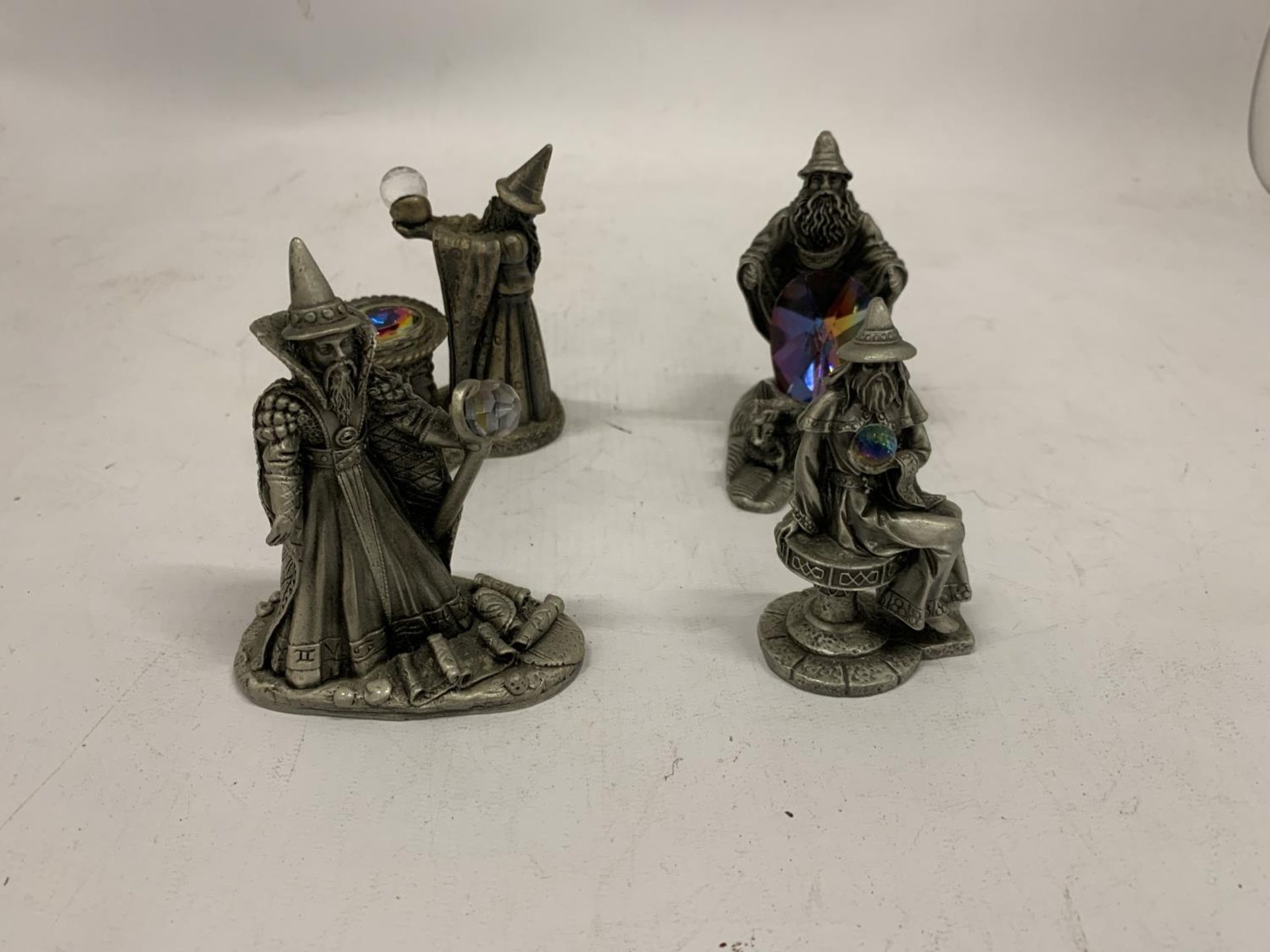 FOUR PEWTER STYLE WIZARDS WITH CRYSTALS