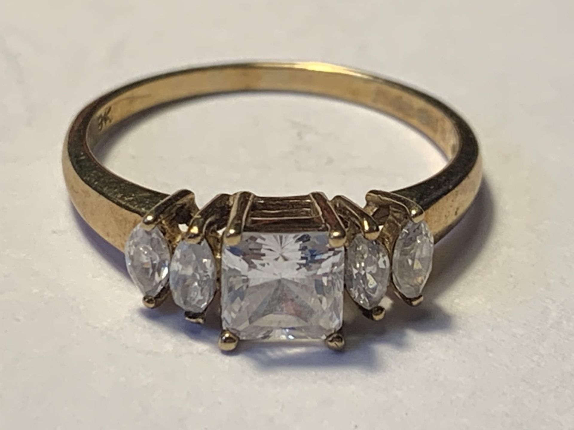 A 9 CARAT GOLD RING WITH CENTRE SQUARE CUBIC ZIRCONIA AND TWO EACH SIDE ON THE SHOULDERS SIZE N