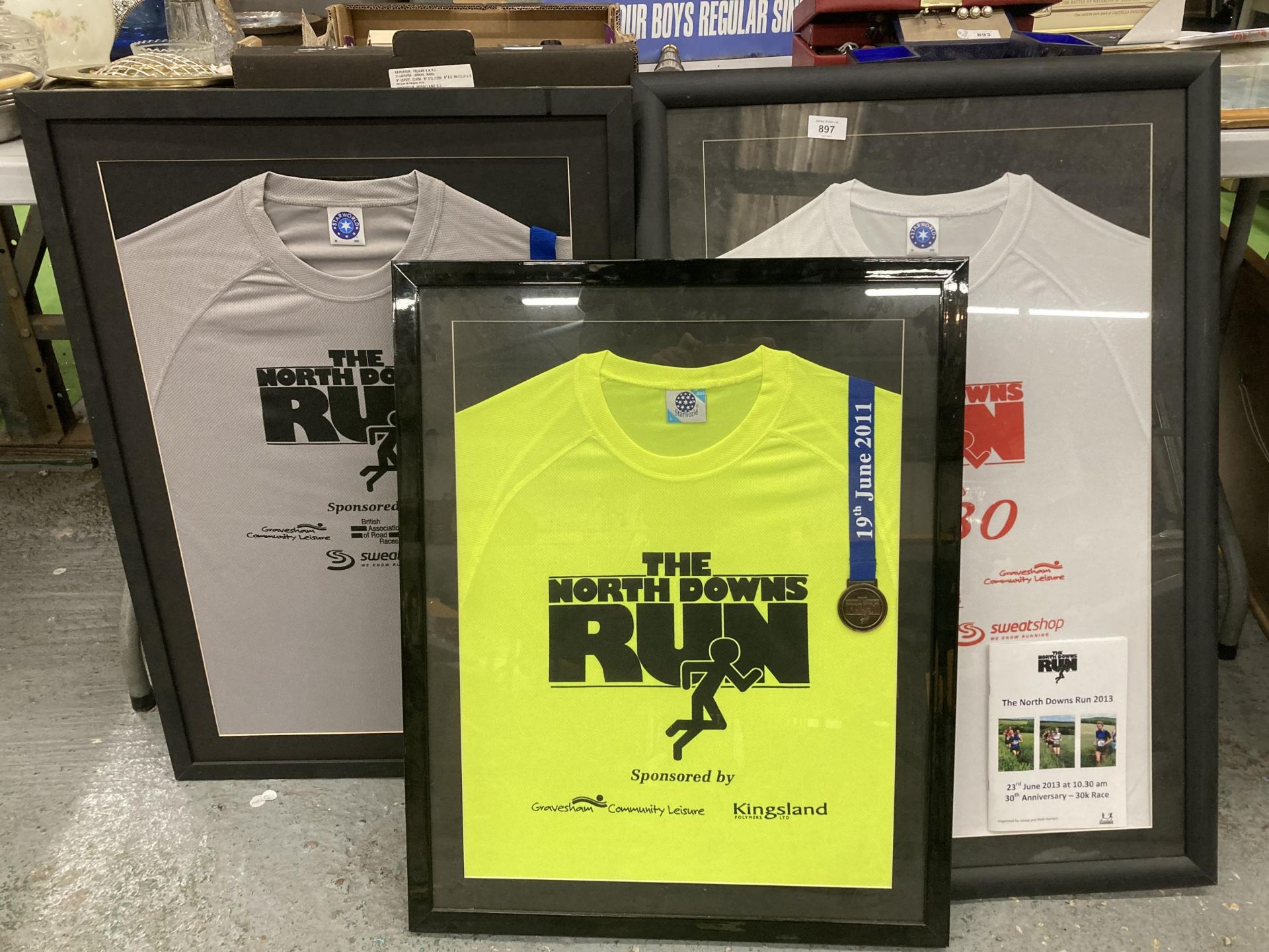 THREE FRAMED AND GLAZED WINNERS SHIRTS AND MEDALS FROM THE NORTH DOWNS RUNS