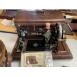 A VINTAGE CASED JONES SEWING MACHINE WITH ORIGINAL BOOKLET