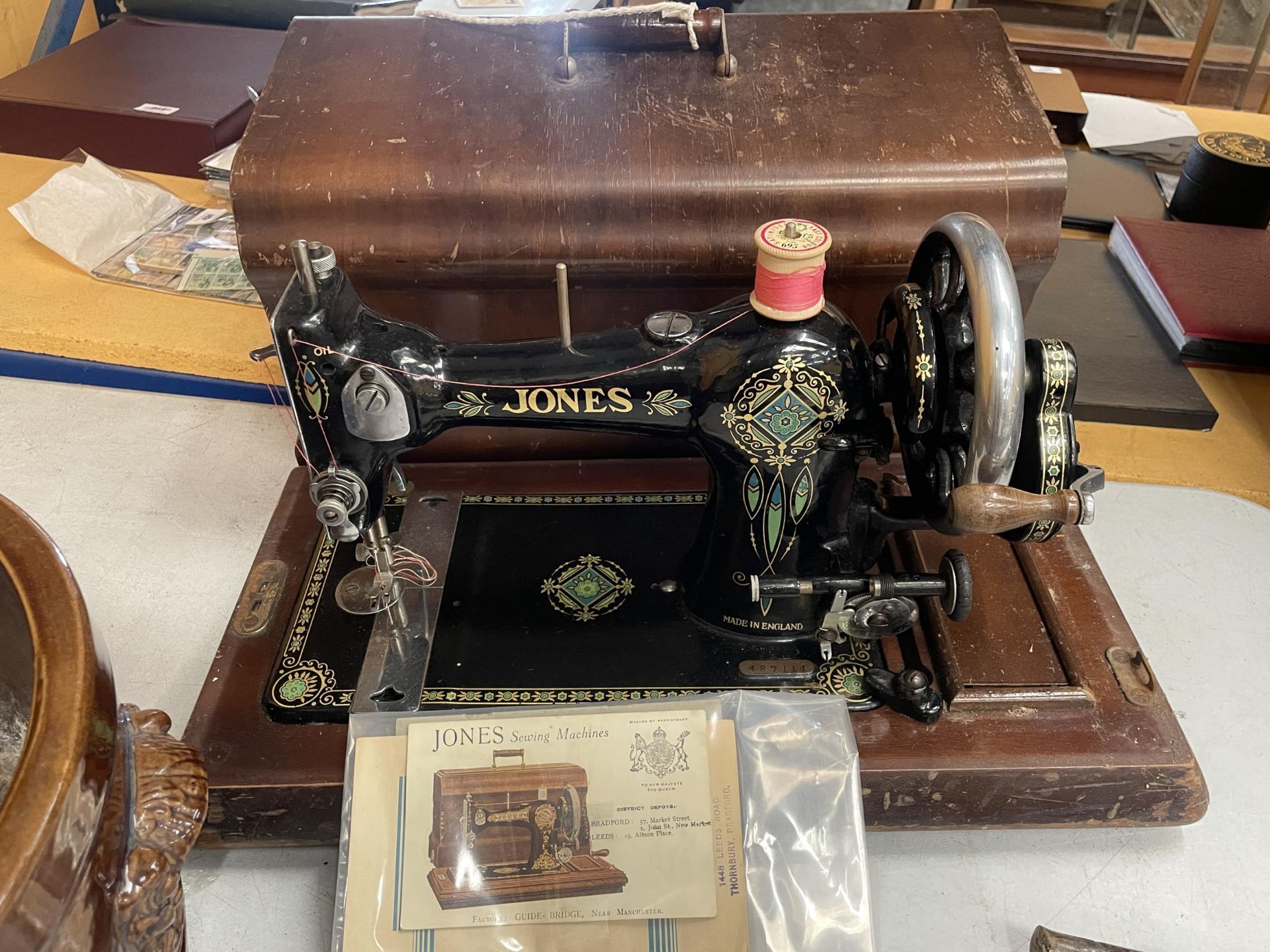 A VINTAGE CASED JONES SEWING MACHINE WITH ORIGINAL BOOKLET