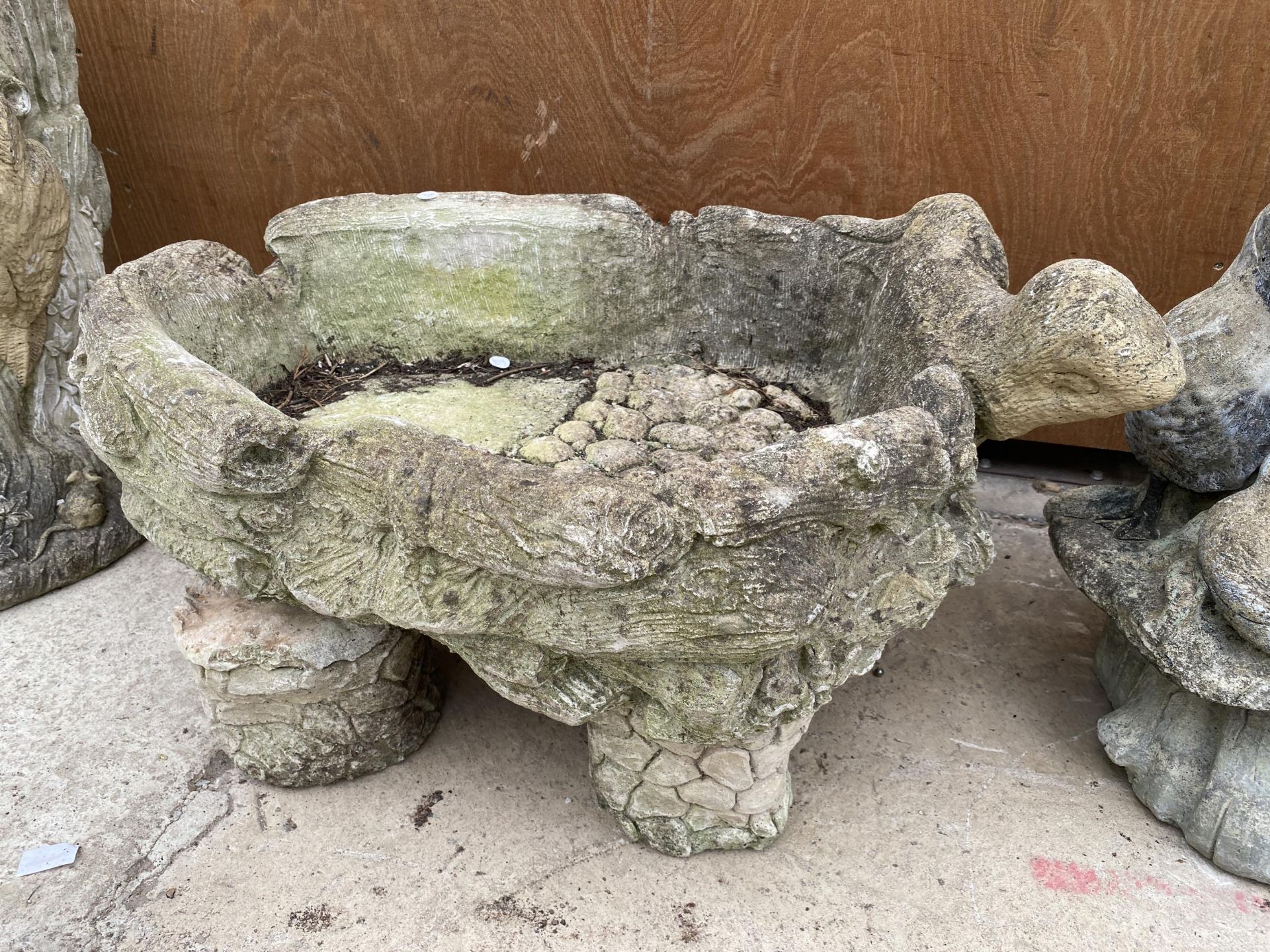 A RECONSTITUTED STONE PLANTER WITH BASE AND OTTER DECORATION