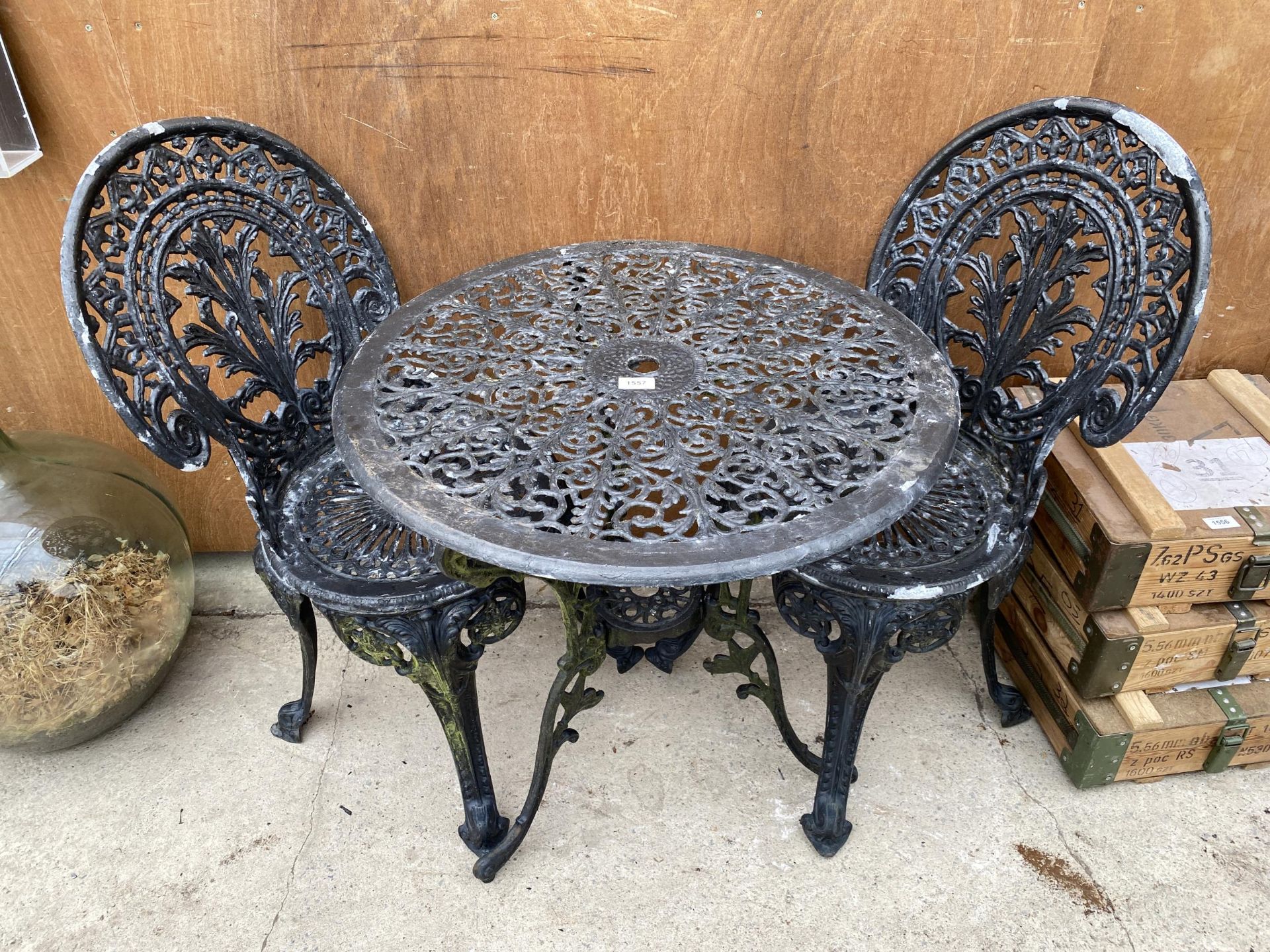 A VINTAGE CAST ALLOY BISTRO SET COMPRISING OF A ROUND TABLE AND TWO CHAIRS