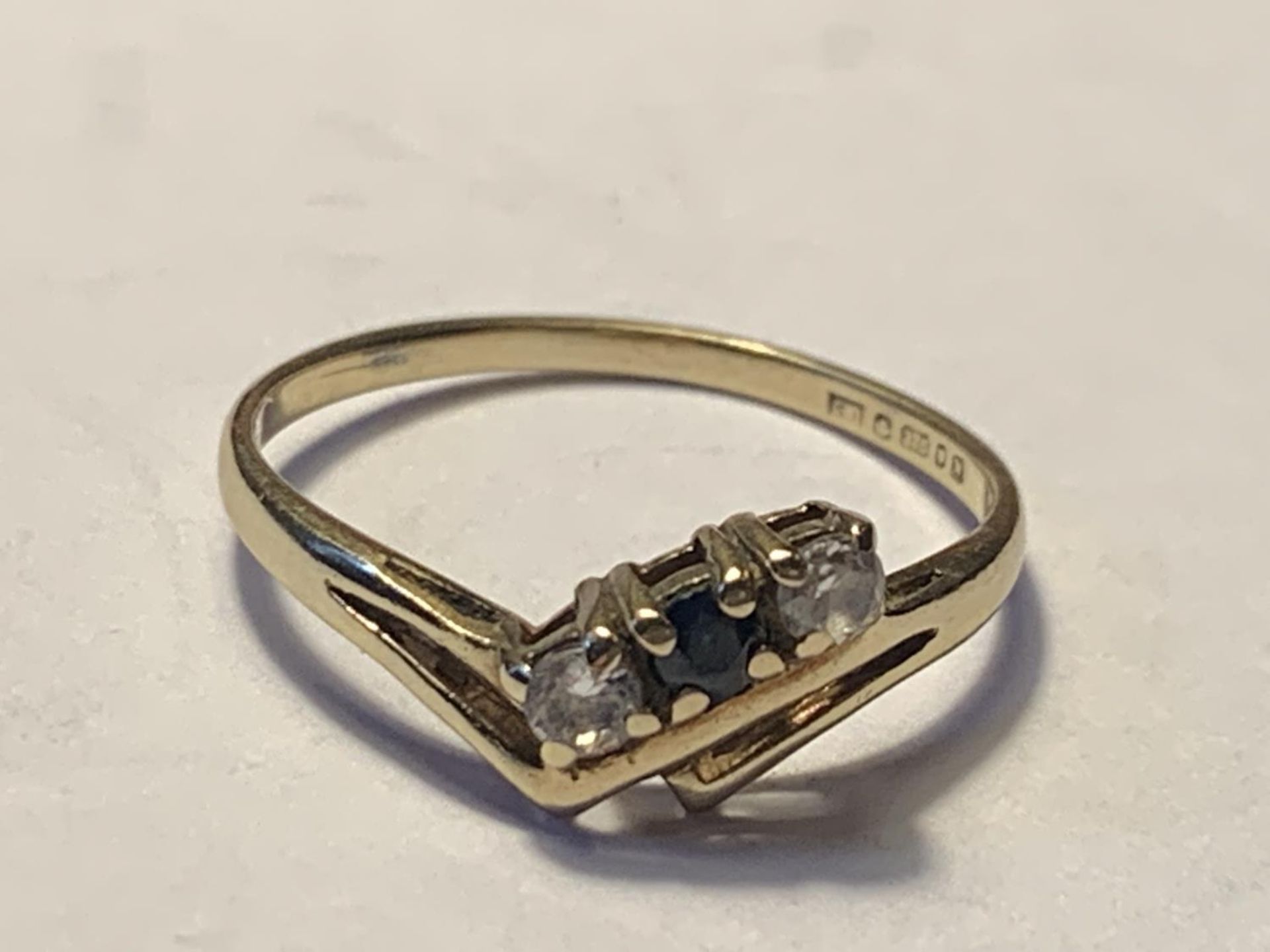 A 9 CARAT WITH A CENTRE SAPPHIRE AND A TWO CUBIC ZIRCONIA SIZE L