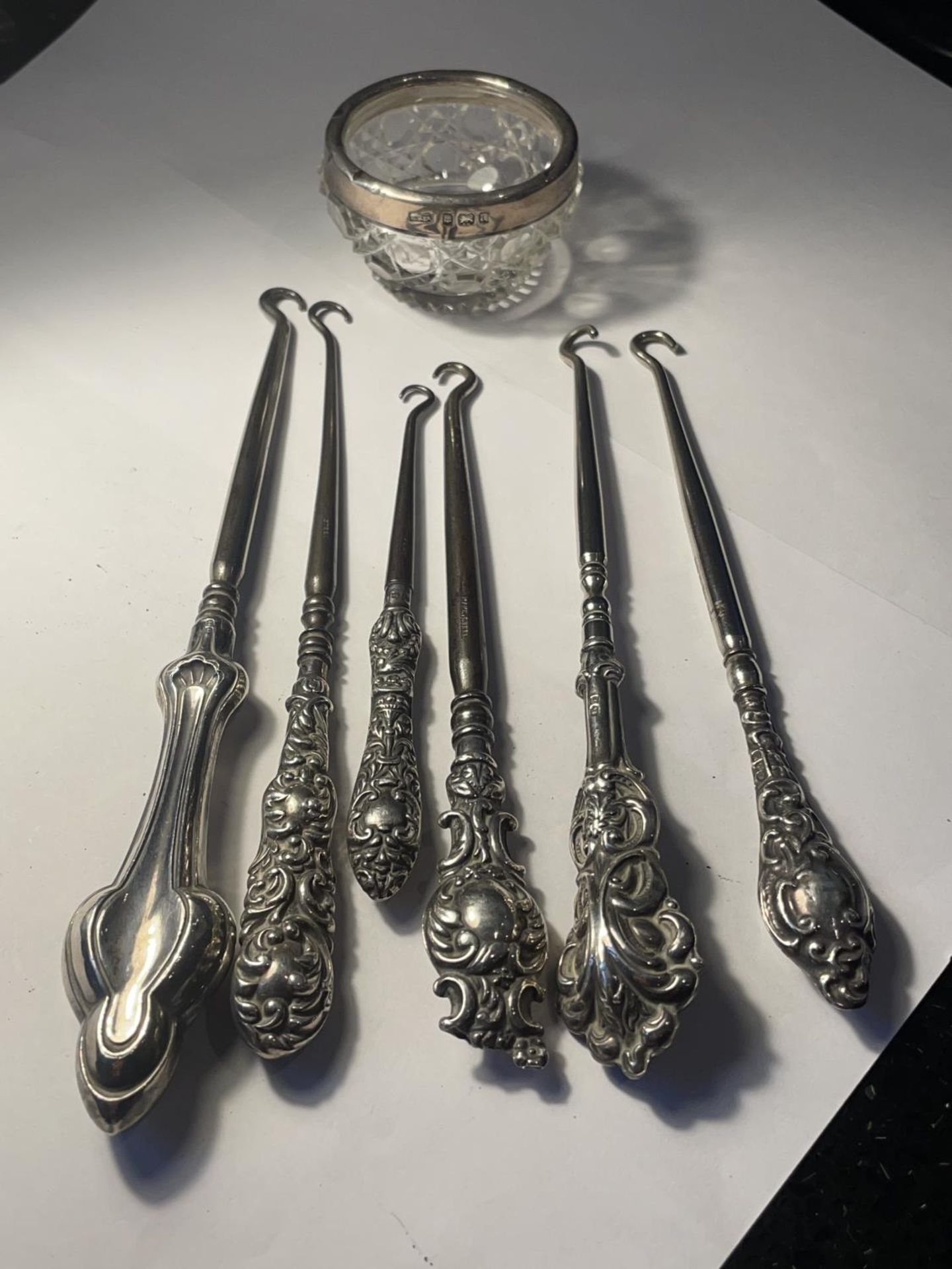 SEVEN HALLMARKED SILVER ITEMS TO INCLUDE FIVE BIRMINGHAM BUTTON HOOKS, A CHESTER BUTTON HOOL AND A