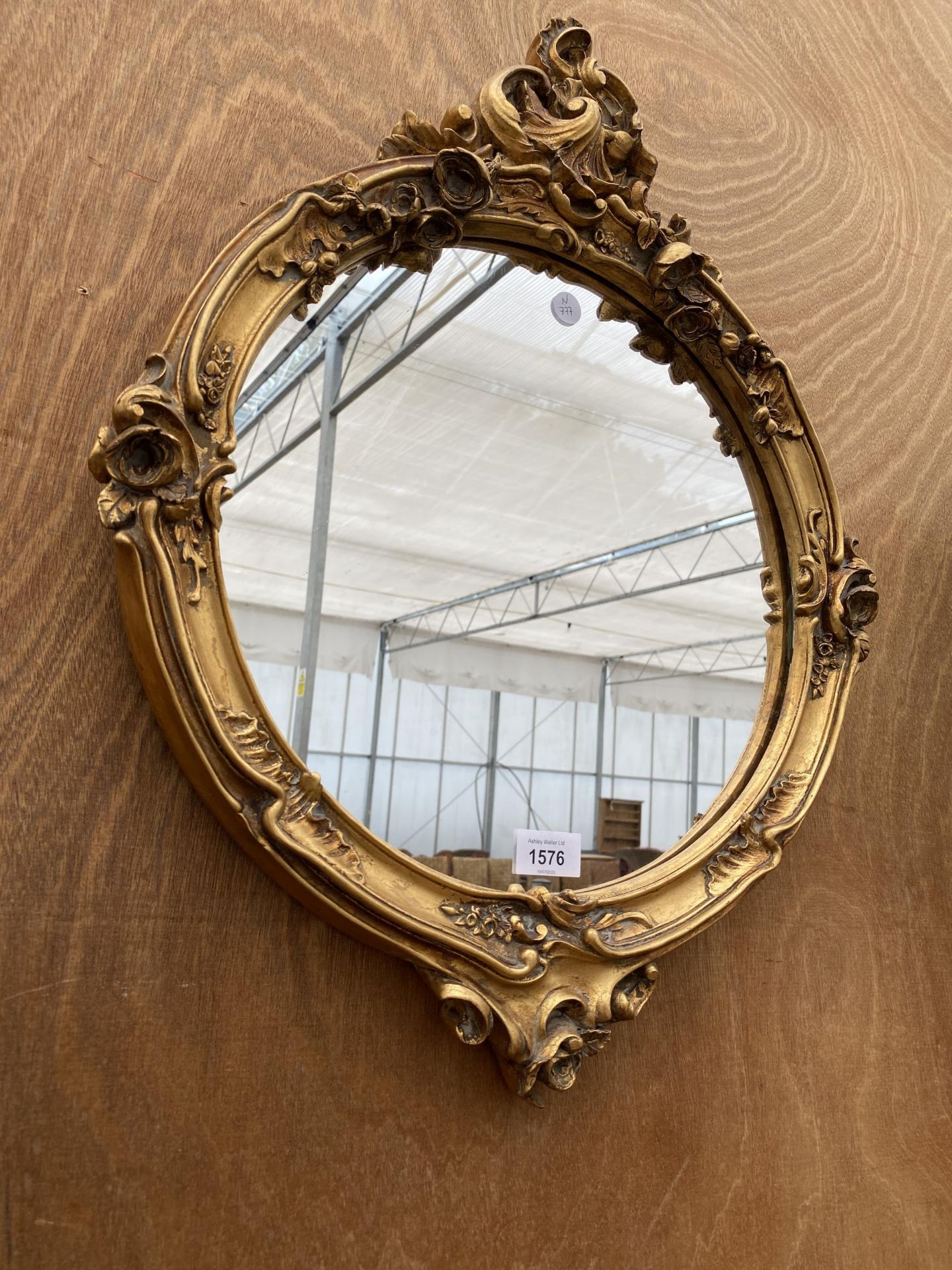 A VINTAGE DECORATIVE CIRCULAR GILT FRAMED WALL MIRROR